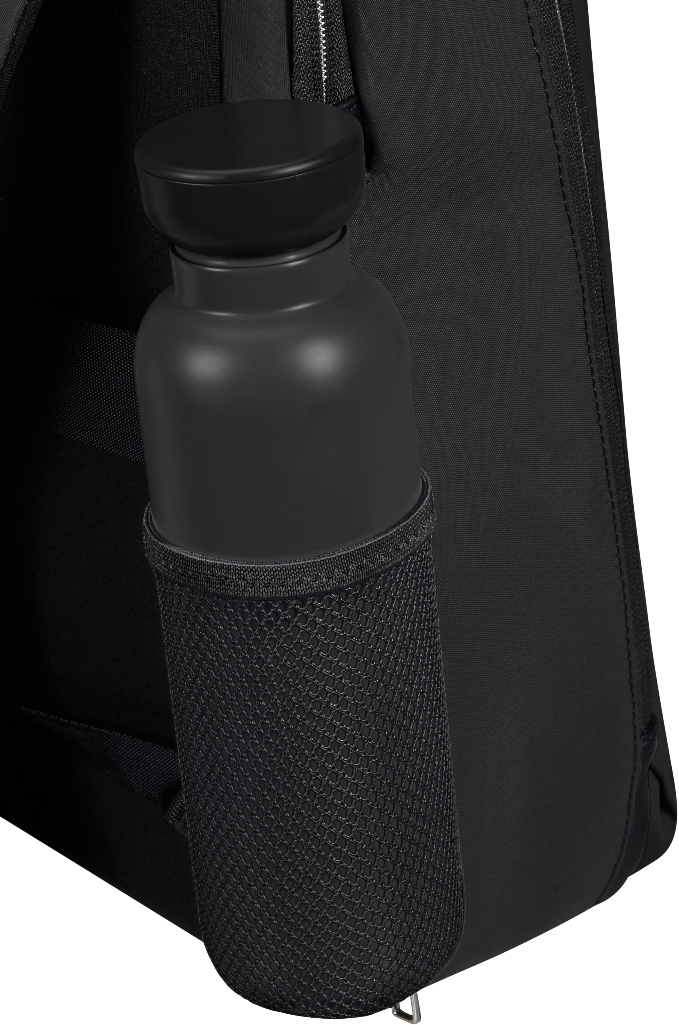 Schwarze Wasserflasche in einer Netztasche auf einem schwarzen Rucksack. Nahaufnahme, Hintergrund unscharf.