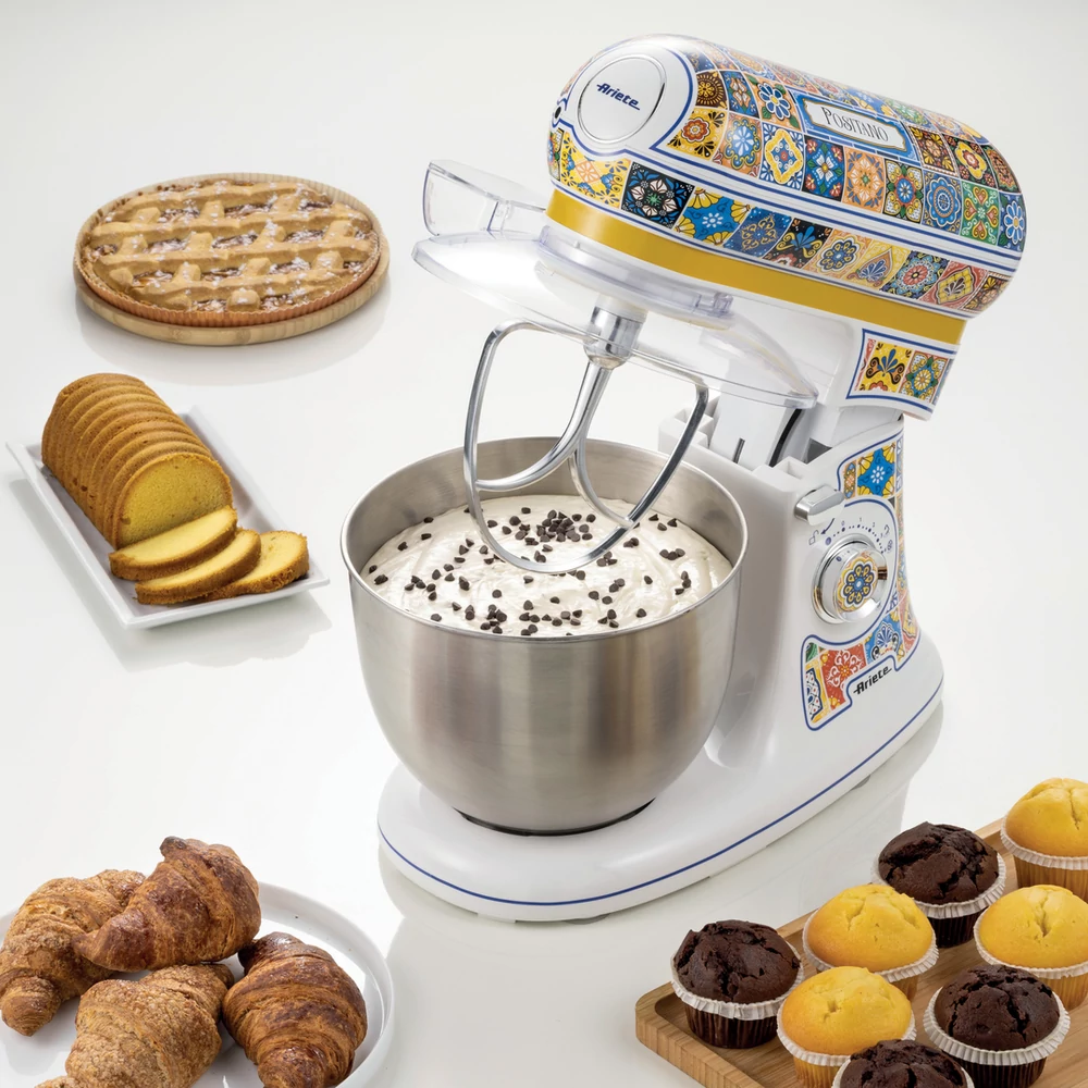 Egy fehér és többszínű robotgép desszertekkel: piték, muffinok és croissant-ok.