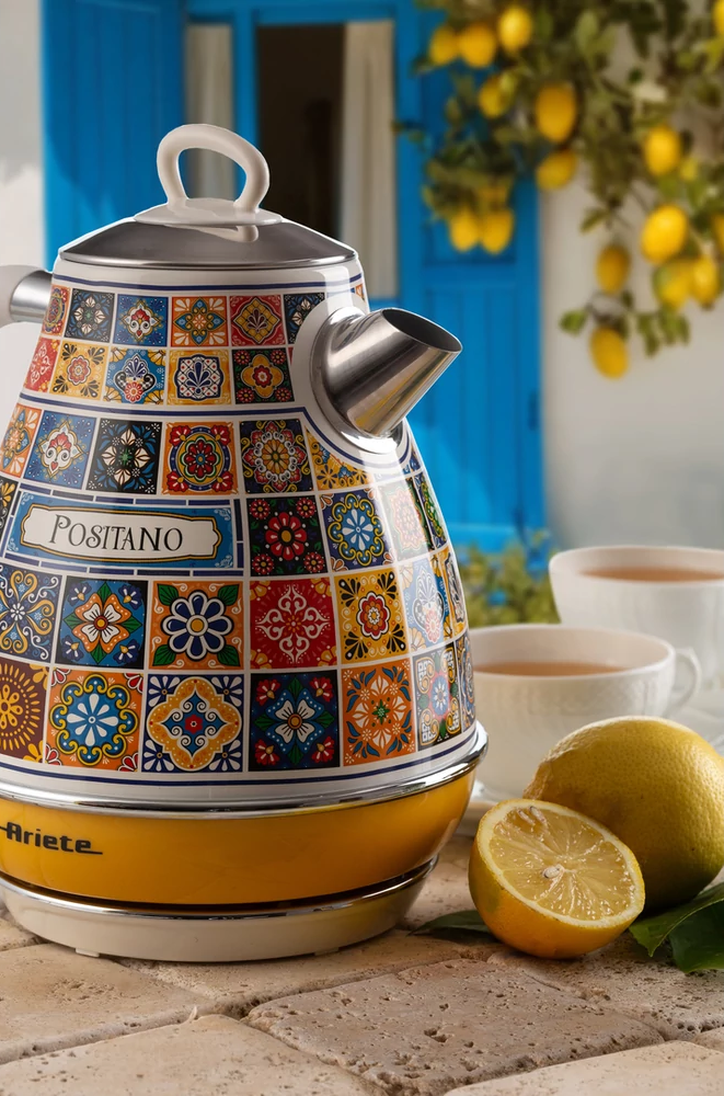 'Positano' feliratú vízforraló csempemintán. Citromok és csészék az asztalon.