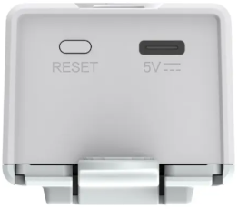 Zbliżenie białego urządzenia. Pokazano przycisk reset i port USB. Urządzenie jest białe.