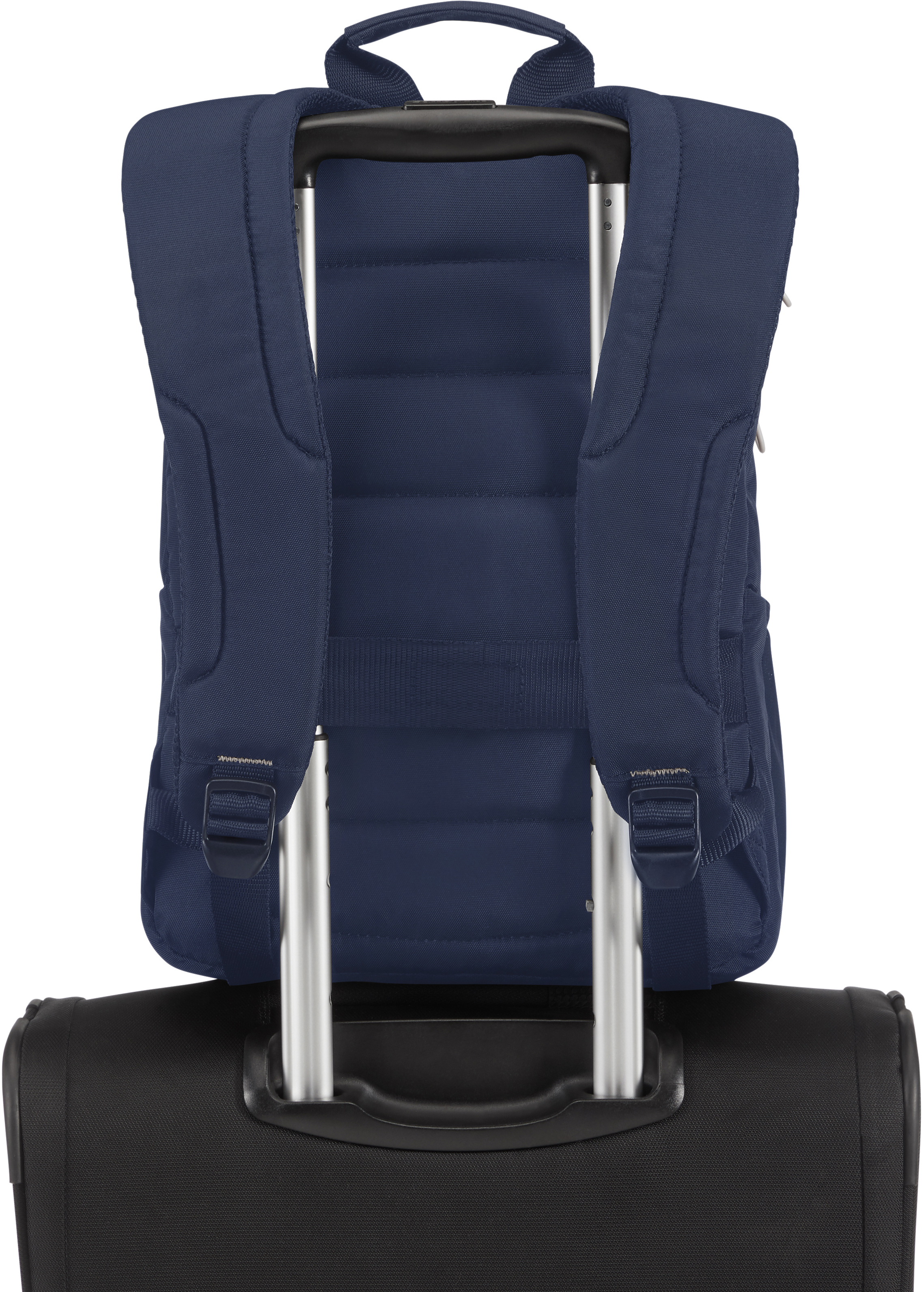 Dunkelblauer Rucksack auf einem schwarzen Koffer mit Griff.