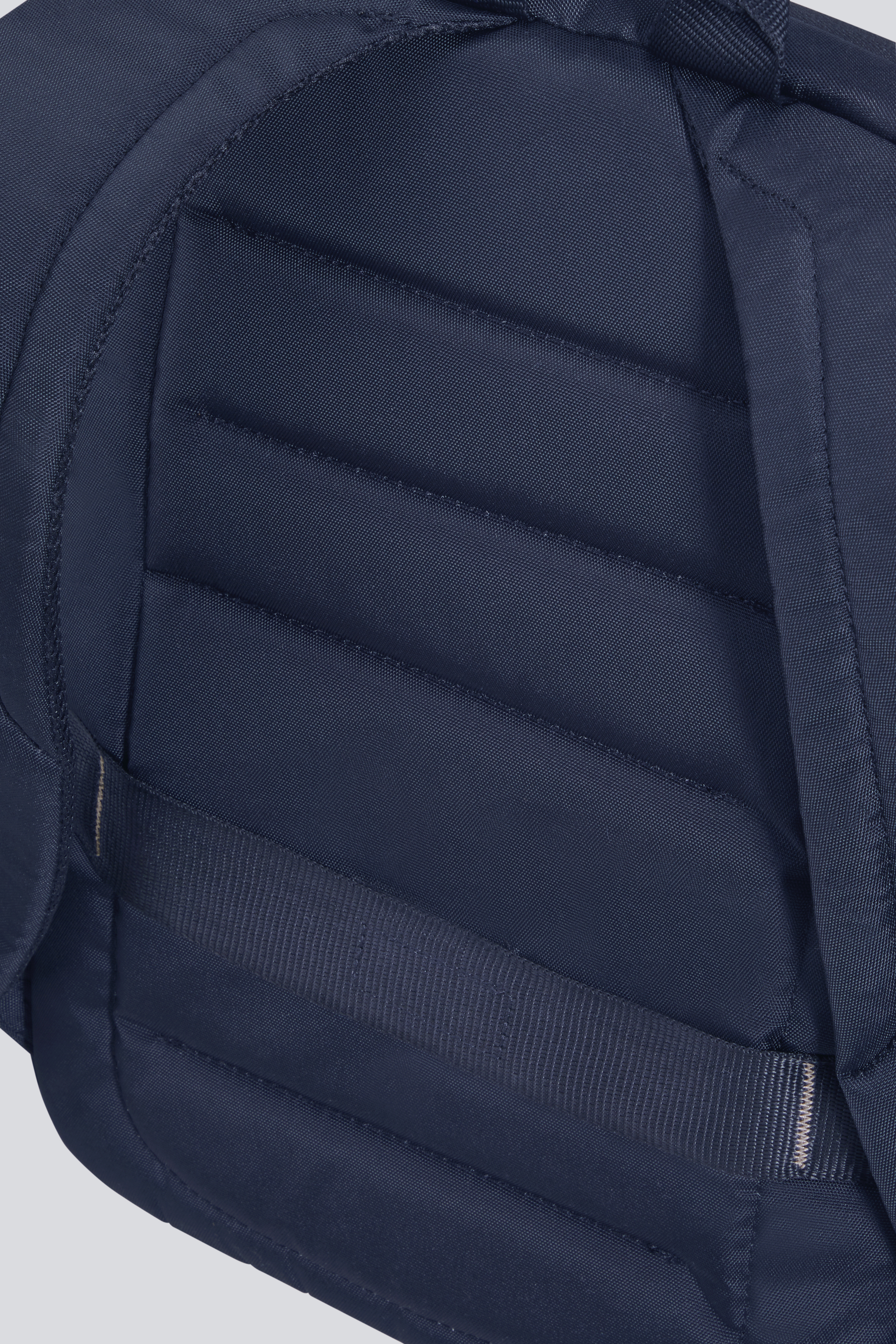 Nahaufnahme eines dunkelblauen Rucksacks mit gepolsterten Schultergurten und einem Griff.