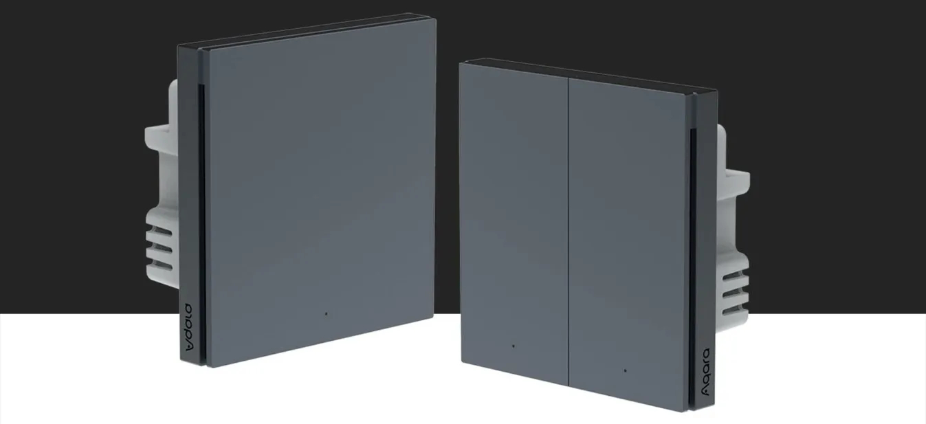 Dwa szare inteligentne włączniki światła. Jeden na białym, drugi na czarnym tle.