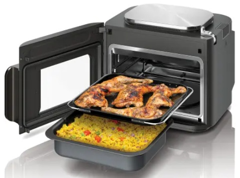 Piekarnik z otwartymi drzwiami, w środku tace z pieczonym kurczakiem i ryżem.