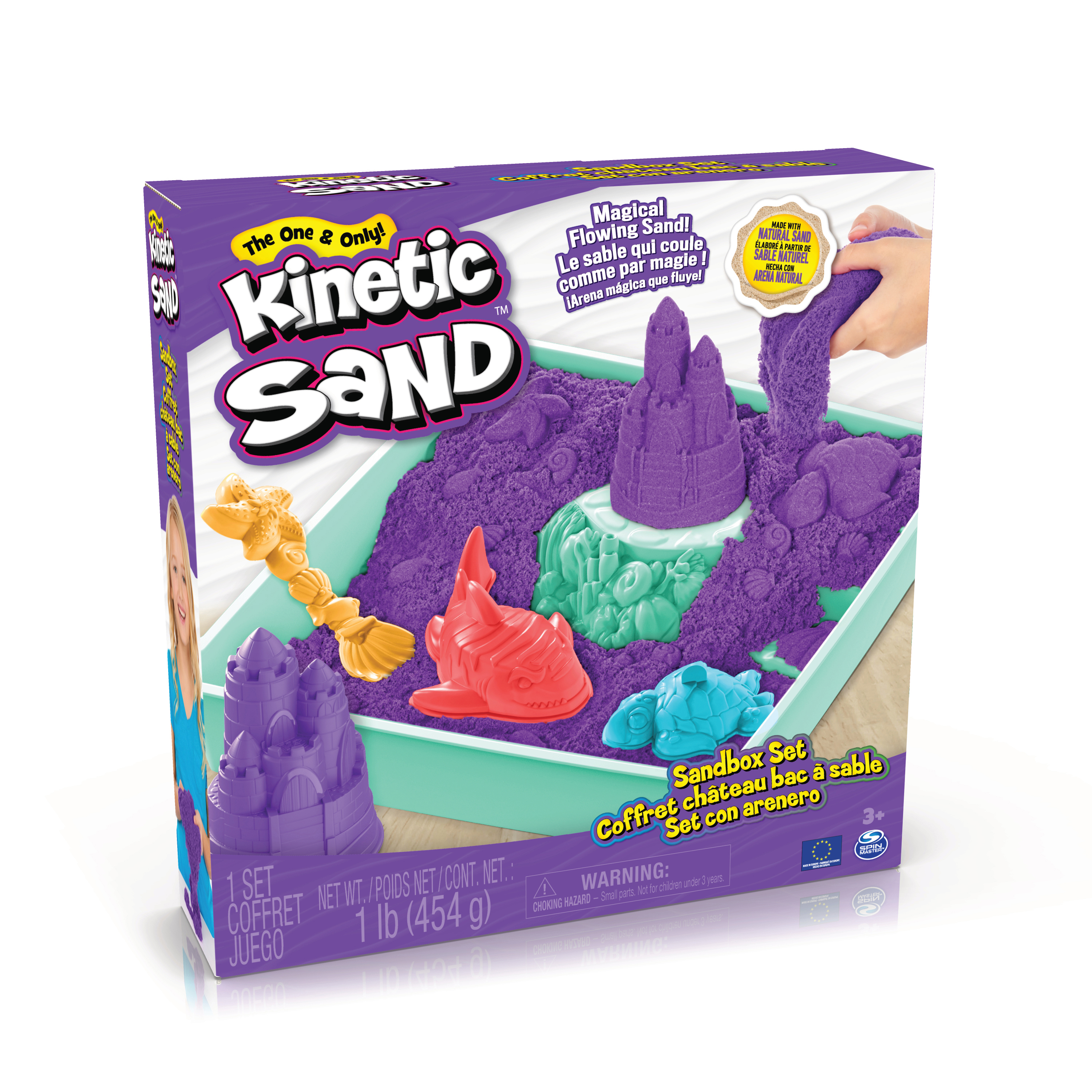 Kinetic Sand-Box mit lila Sand, Spielzeugschlössern und Meereskreaturen, mit einer Kinderhand, die Sand gießt.