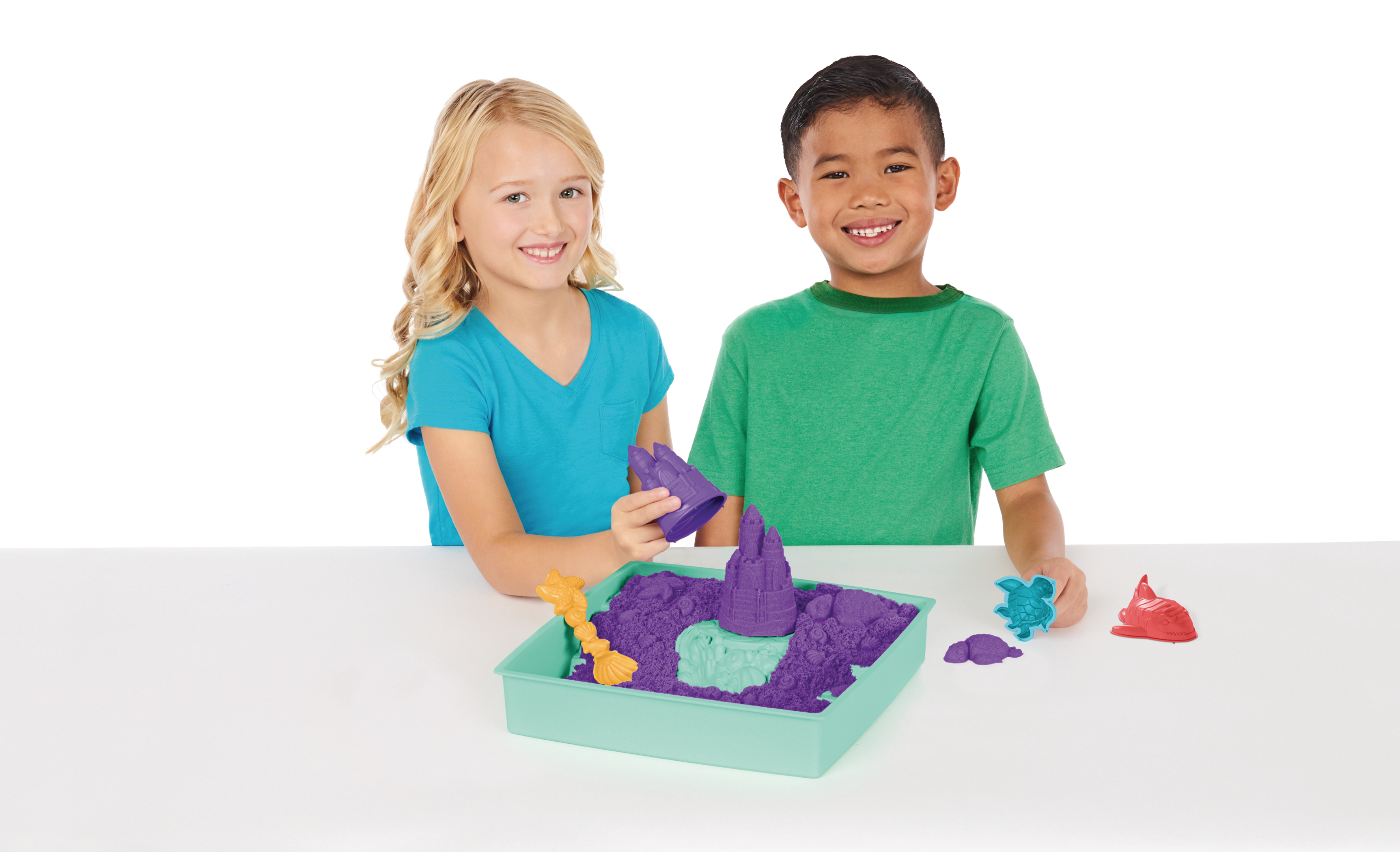 Zwei Kinder spielen mit kinetischem Sand in einer Schale.
