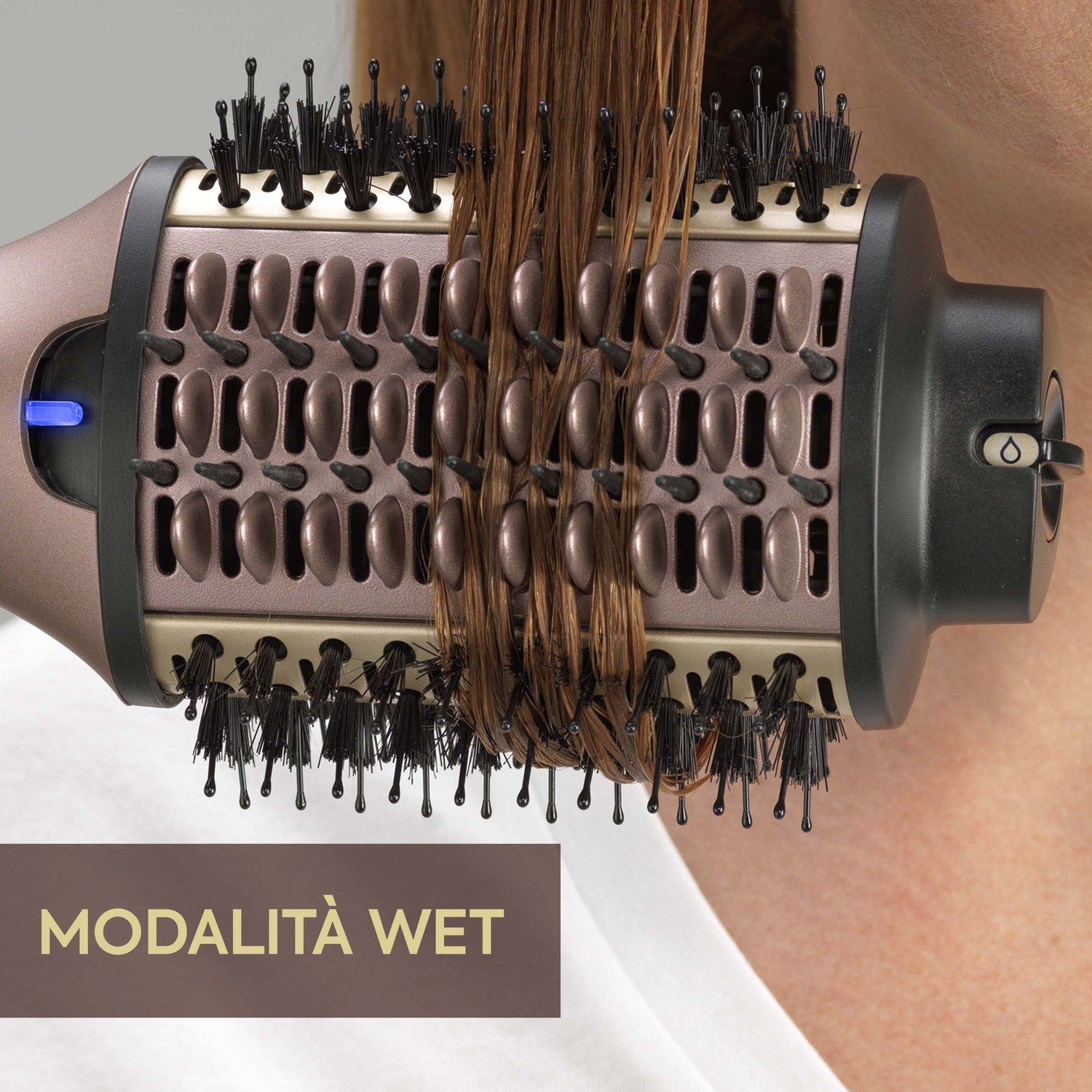 Spazzola per capelli con capelli bagnati. Il testo dice: Modalità Wet. Lo sfondo è oro sfocato.