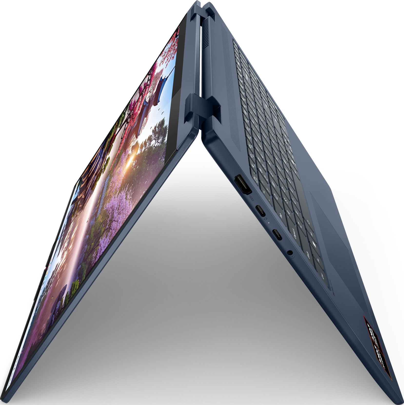 Blauer Laptop offen, zeigt ein farbenfrohes Bild. Die Tastatur ist sichtbar, vor schwarzem Hintergrund.