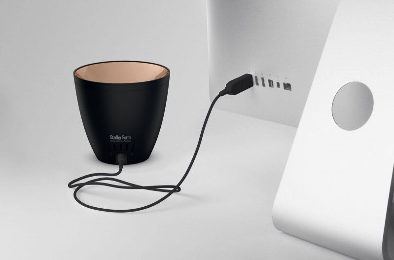 Czarne urządzenie ze złotym wnętrzem jest podłączone do komputera.