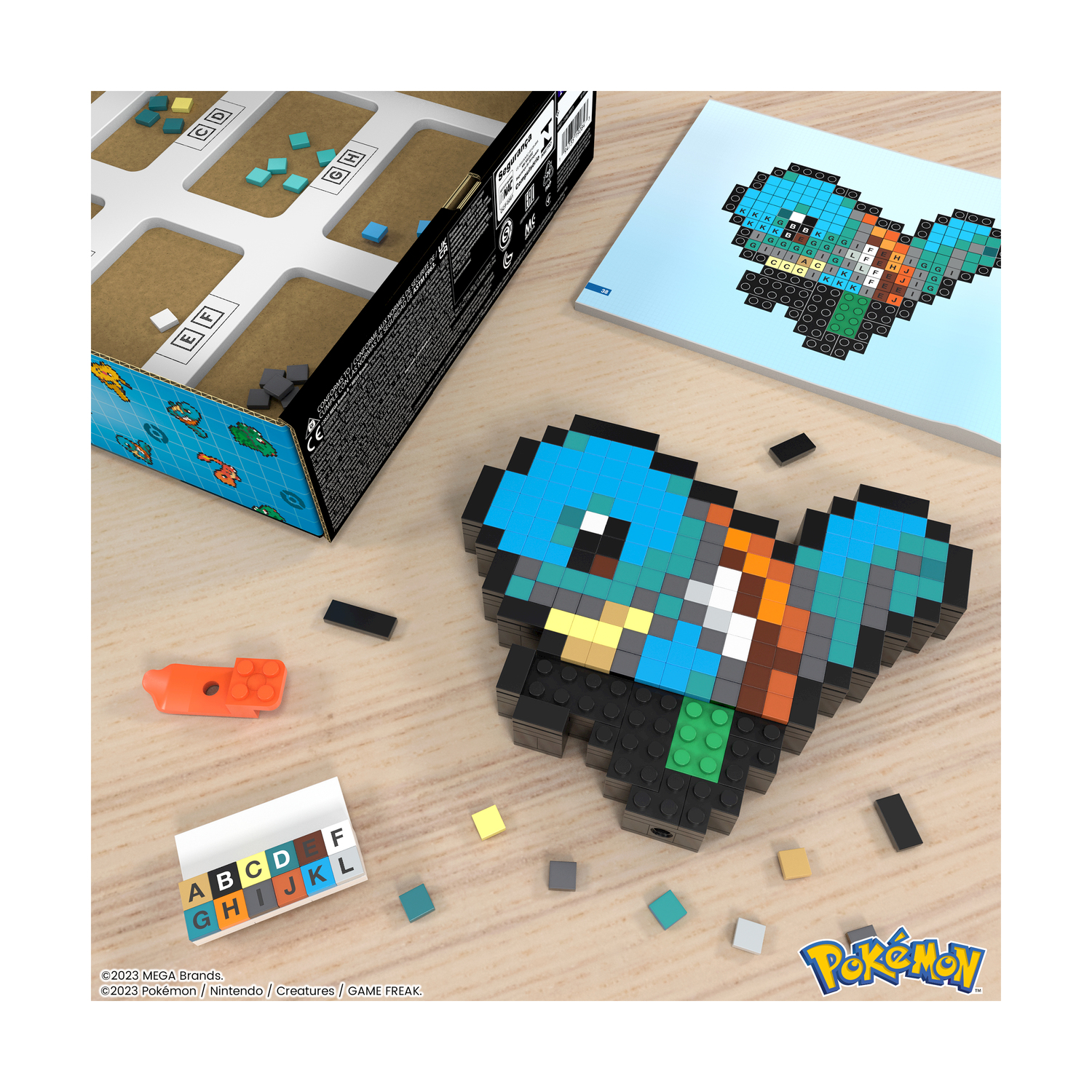 Kit pixel art Pokémon con Squirtle, scatola aperta, blocchi e istruzioni.
