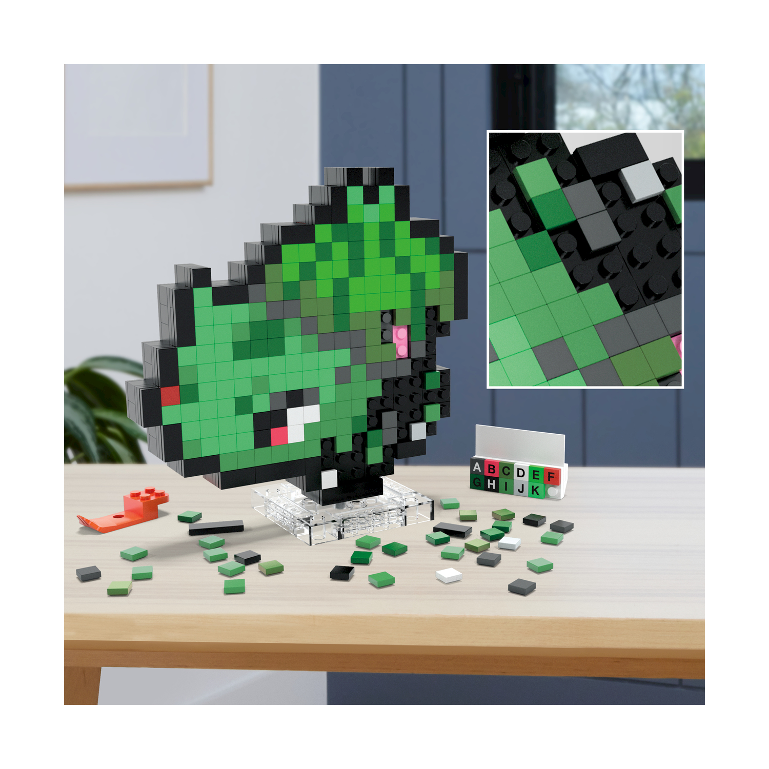 Una figura pixelata verde e nera, un modello, su un tavolo con blocchi e schede alfabetiche.