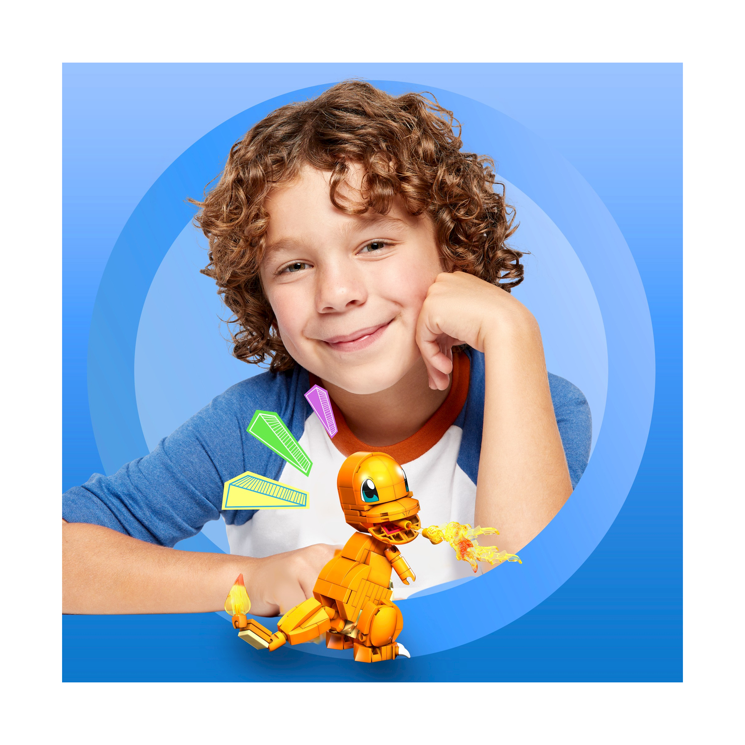 Un ragazzo sorride alla fotocamera con un set Lego Charmander, sfondo blu.