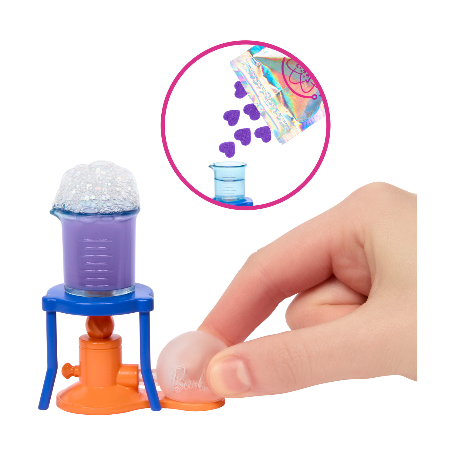 Una mano tocca una bolla trasparente. Becher con bolle su supporto. Confezione con cuori viola sopra.