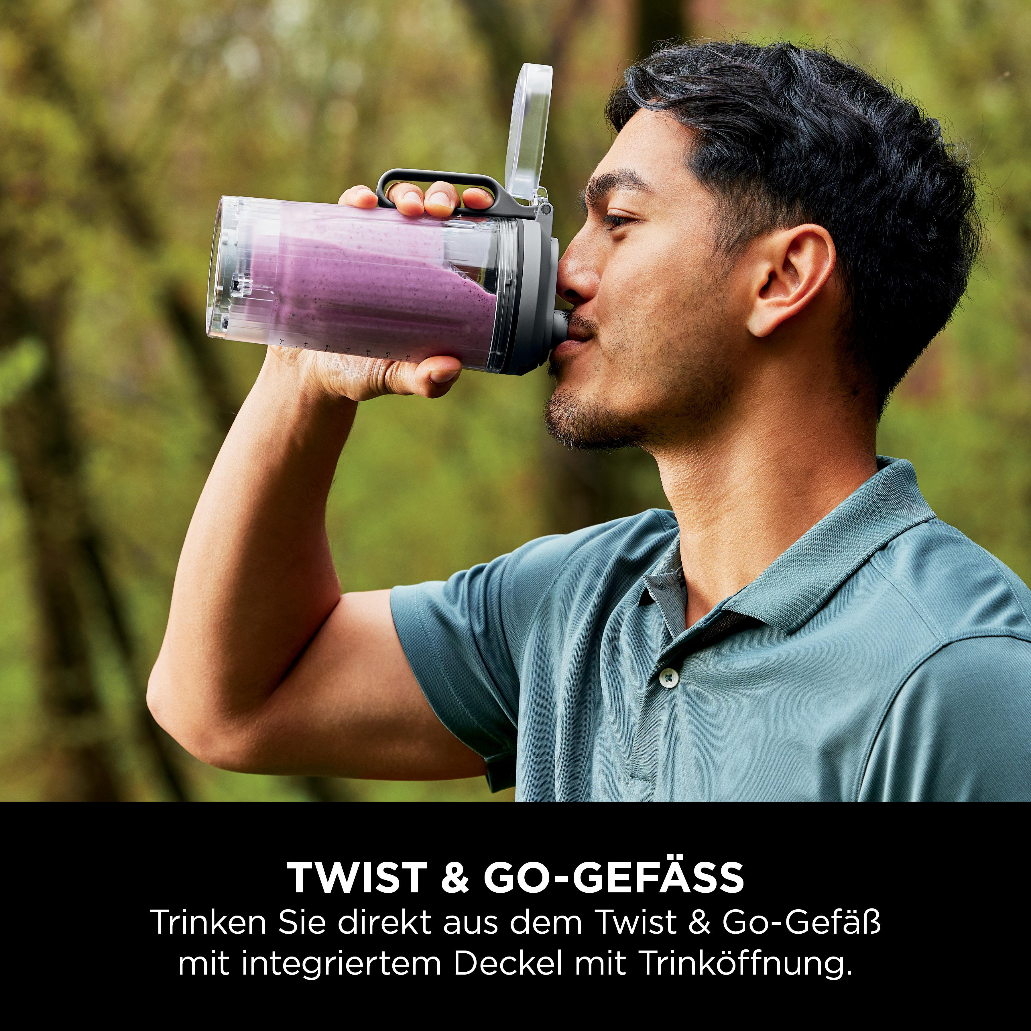 Mann trinkt aus einer Ninja-Blender-Flasche. Die Flasche hat einen lila Smoothie.