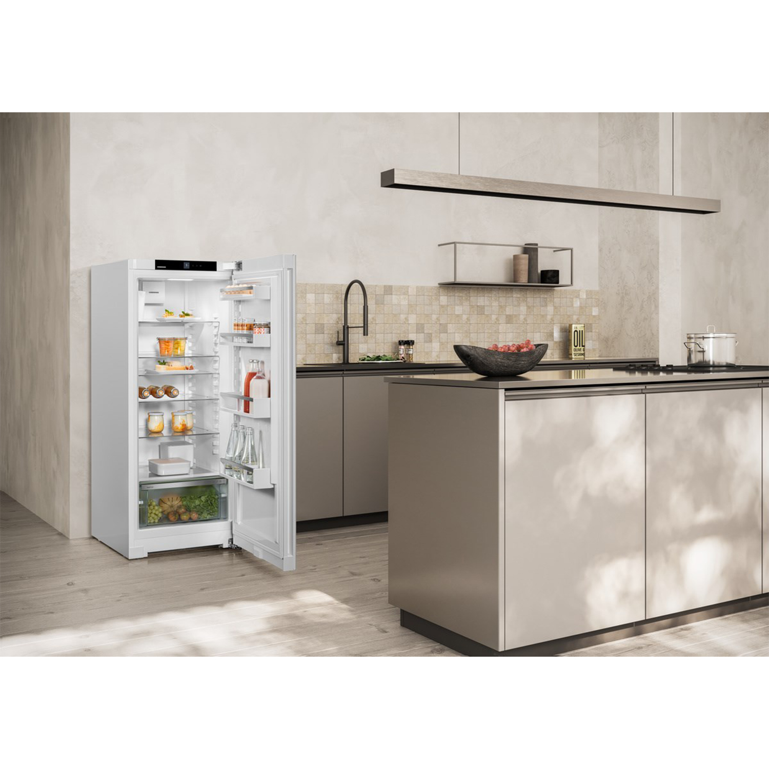 Un frigorifero è aperto. All'interno ci sono vari alimenti. Cucina sullo sfondo.