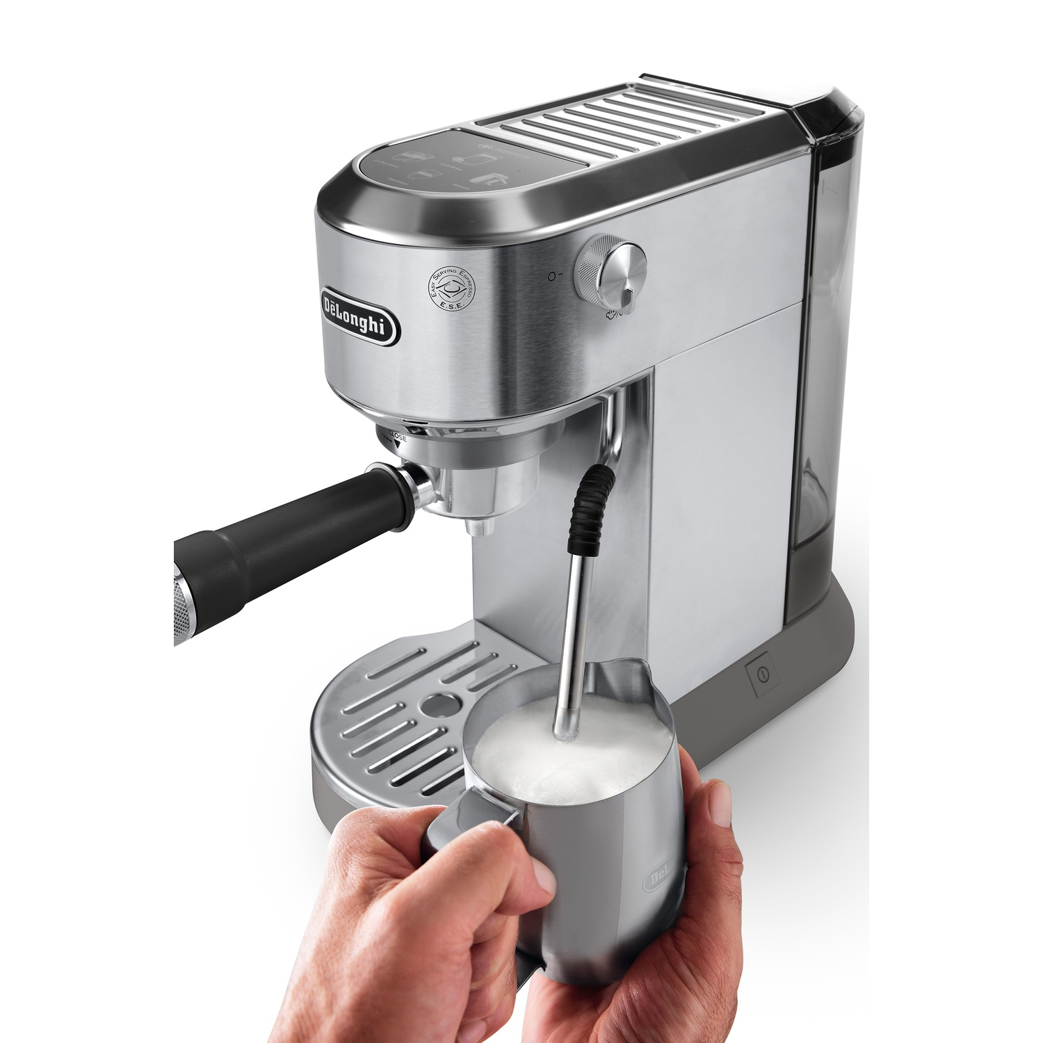 Silver espresso machine with milk frothing. Hand holding a milk pitcher.