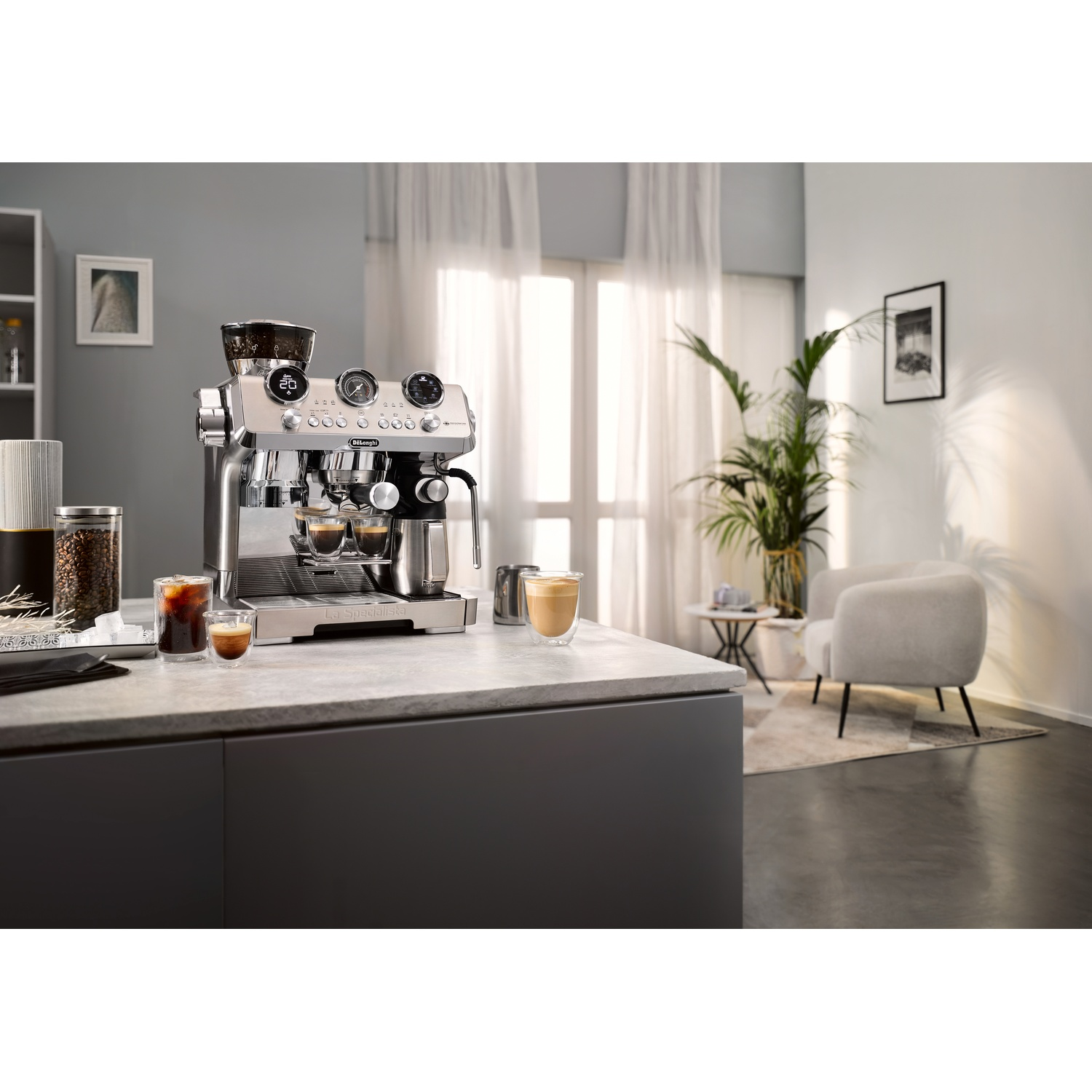 A silver espresso machine on a countertop with a window.