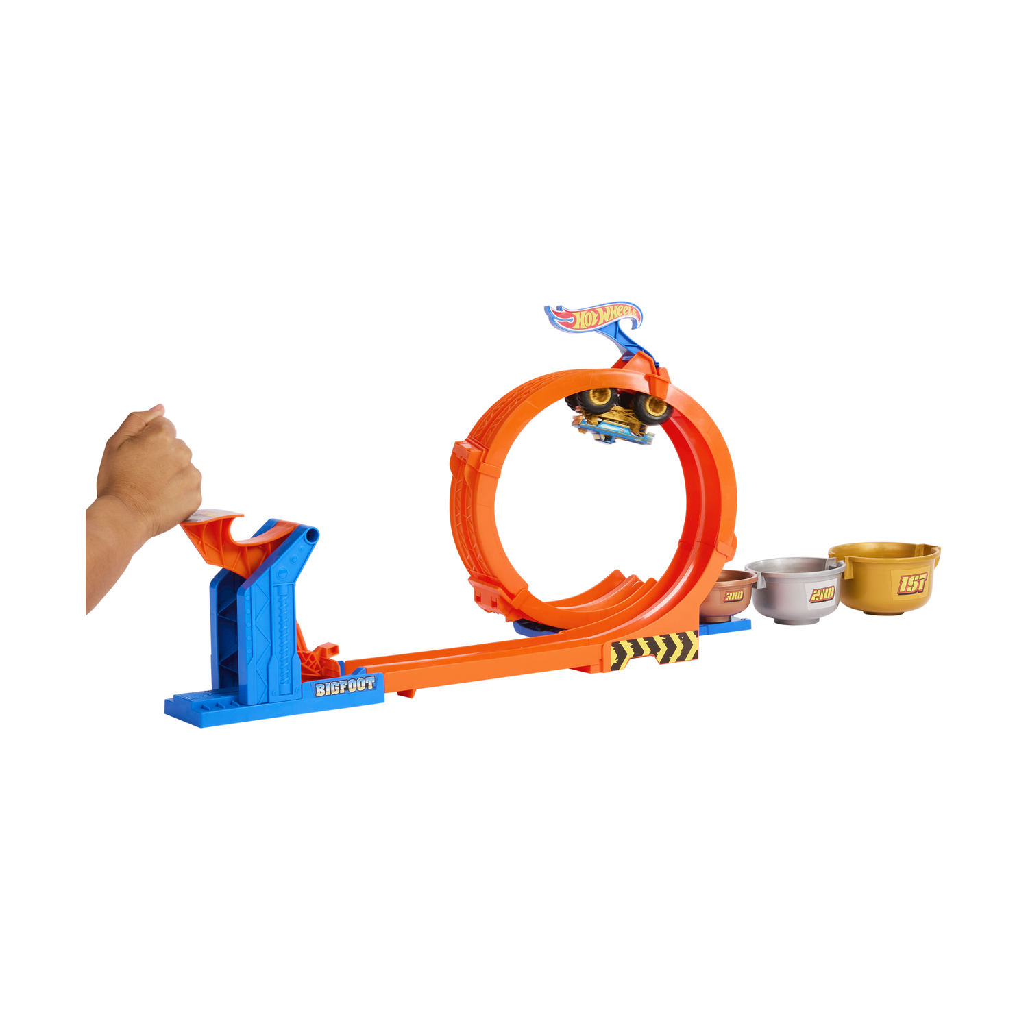 Pista Hot Wheels con anello e auto in aria. La mano tira la leva.