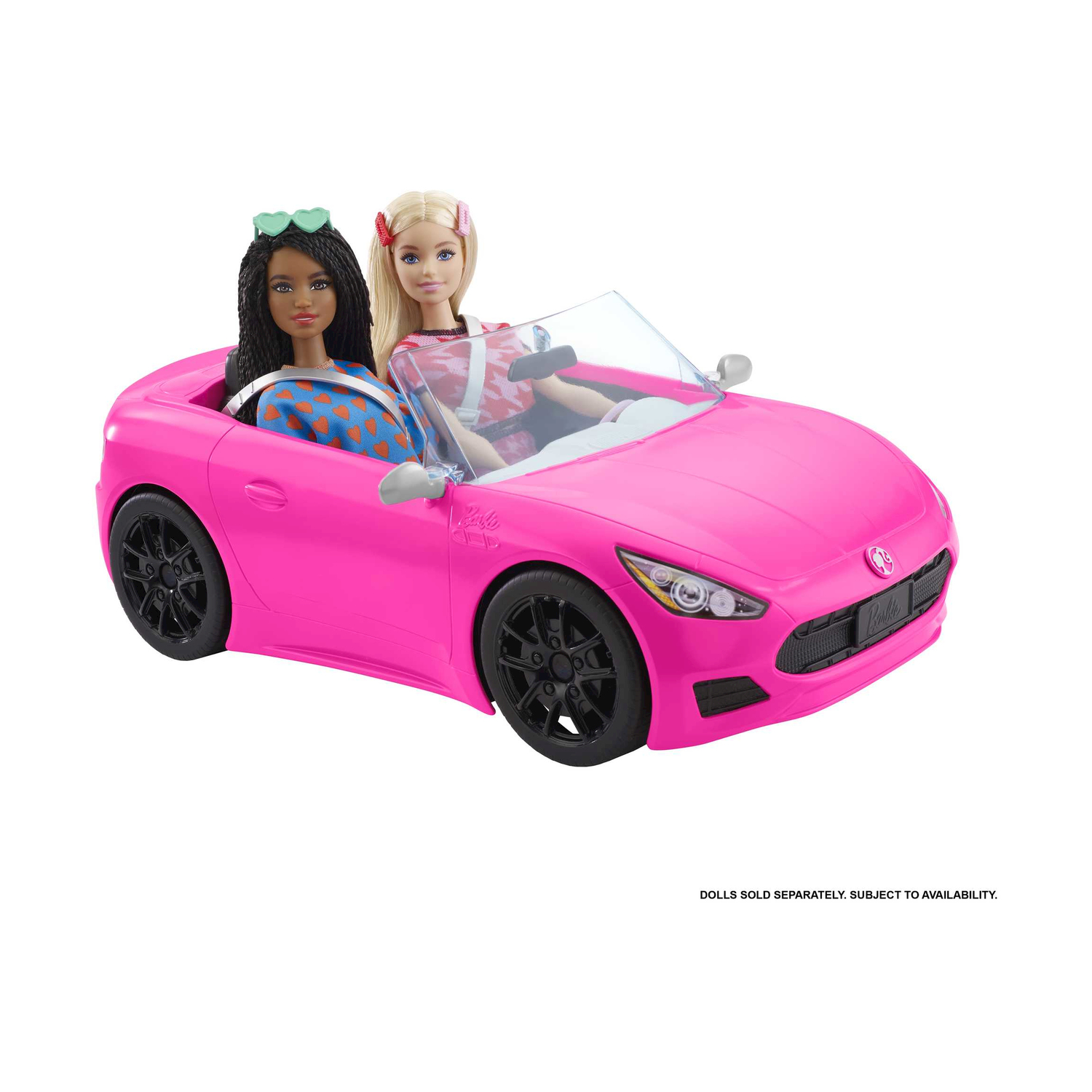 Bambole Barbie in un'auto rosa. Primo piano: auto e bambole. Sfondo: bianco.