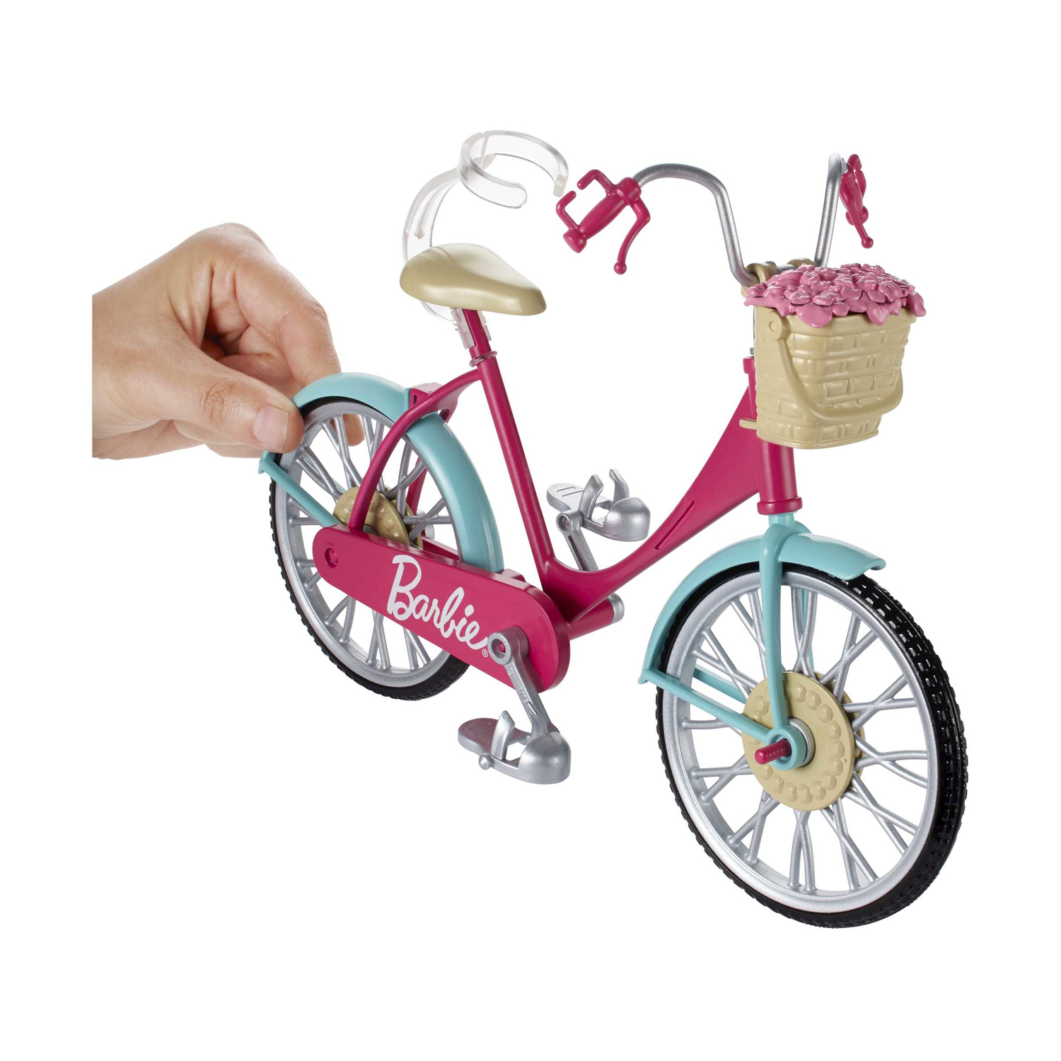 Bicicletta Barbie rosa con un cestino di fiori, tenuta da una mano, su sfondo bianco.