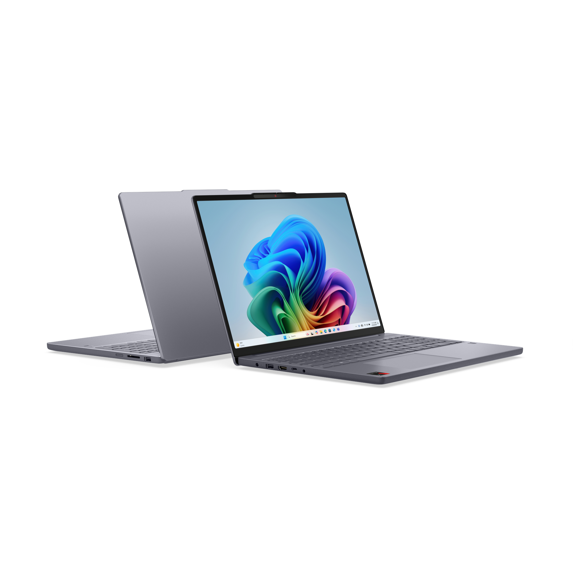 Grauer Laptop geöffnet, ein anderer dahinter geschlossen, auf weißem Hintergrund. Bunter Bildschirm.