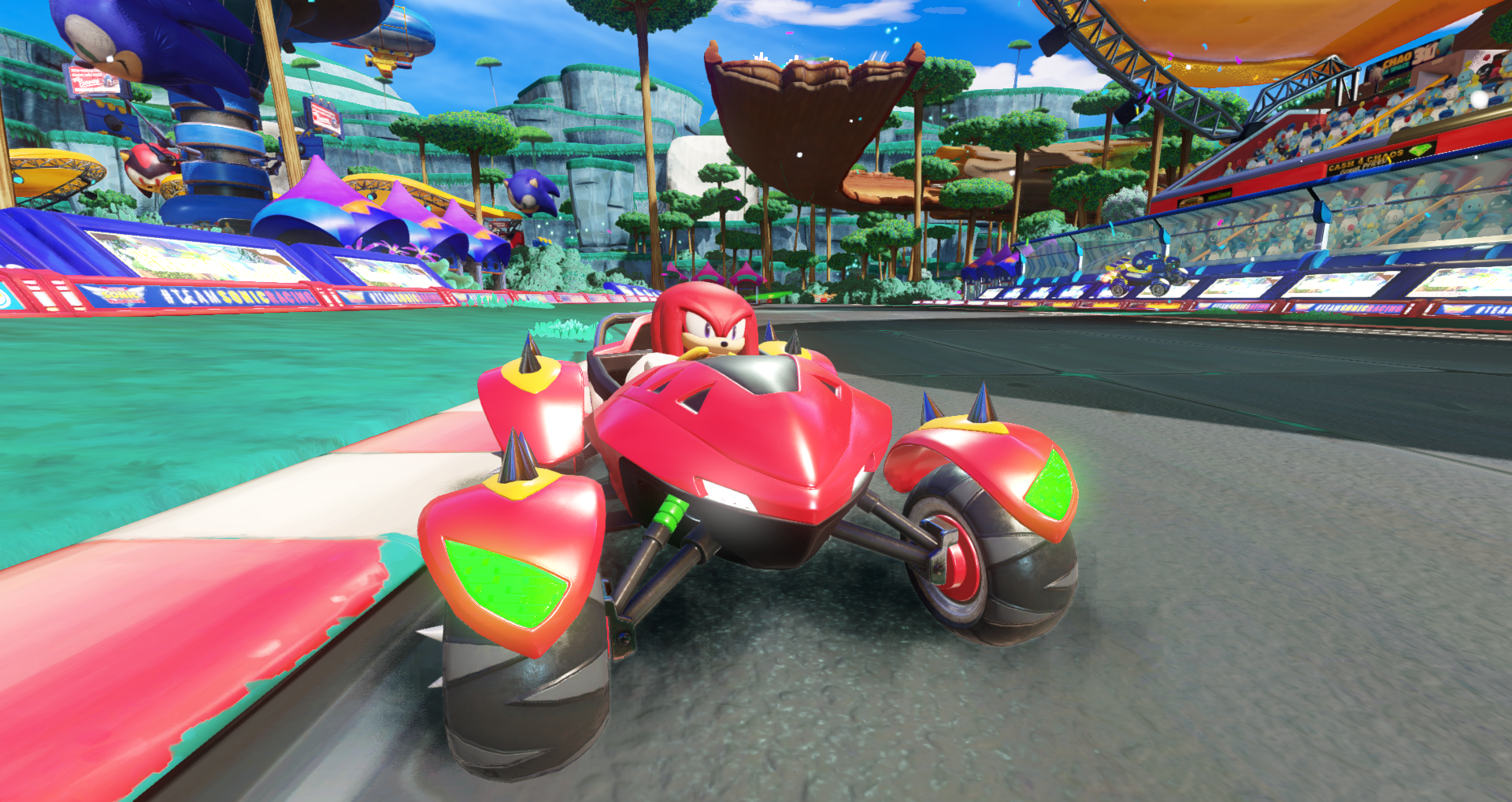 Knuckles fait du karting dans un véhicule rouge sur un circuit. Le ciel est bleu.