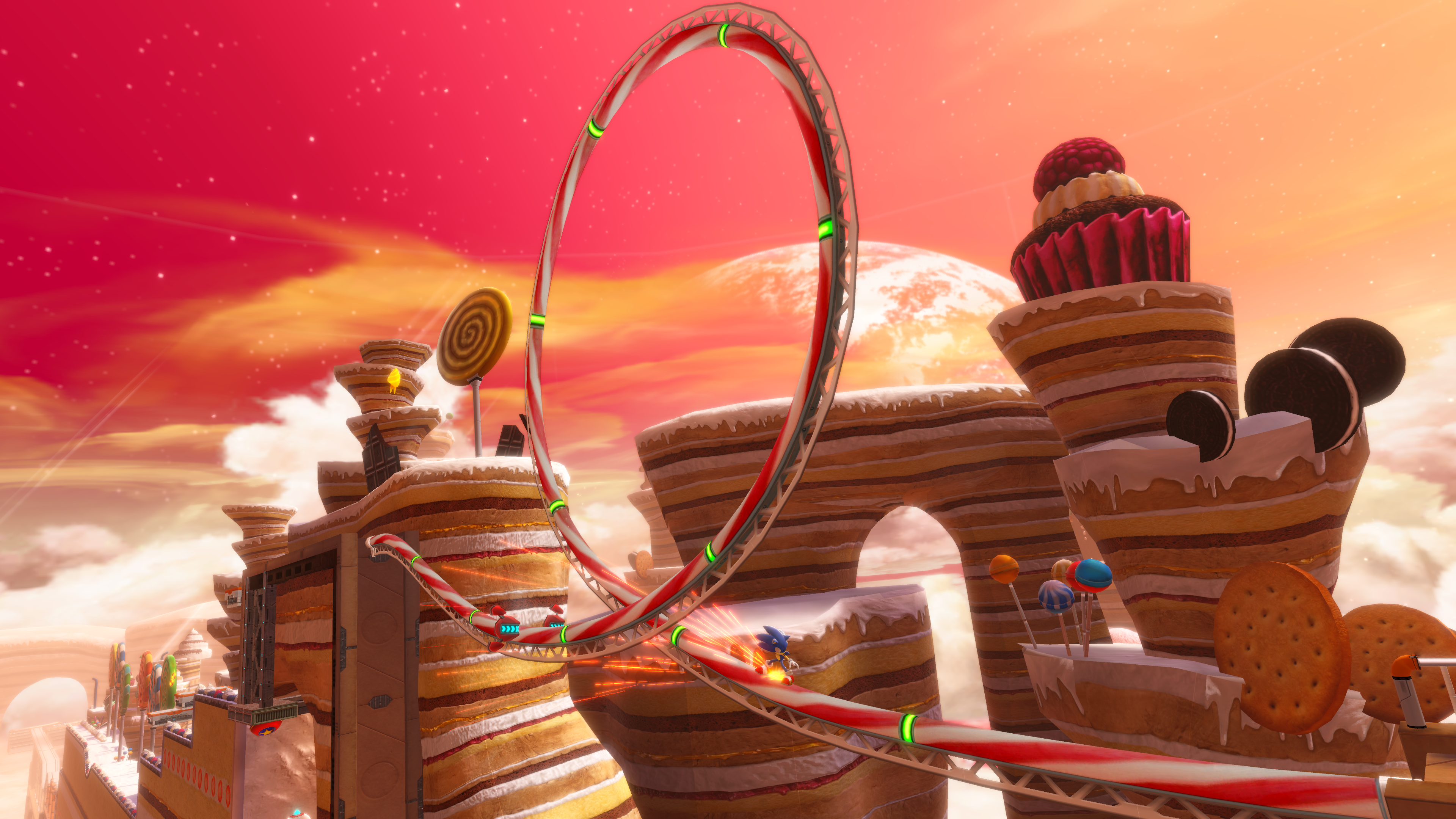Una scena del gioco di Sonic con una pista a loop in un mondo a tema caramelle. Si vedono cupcake e biscotti.