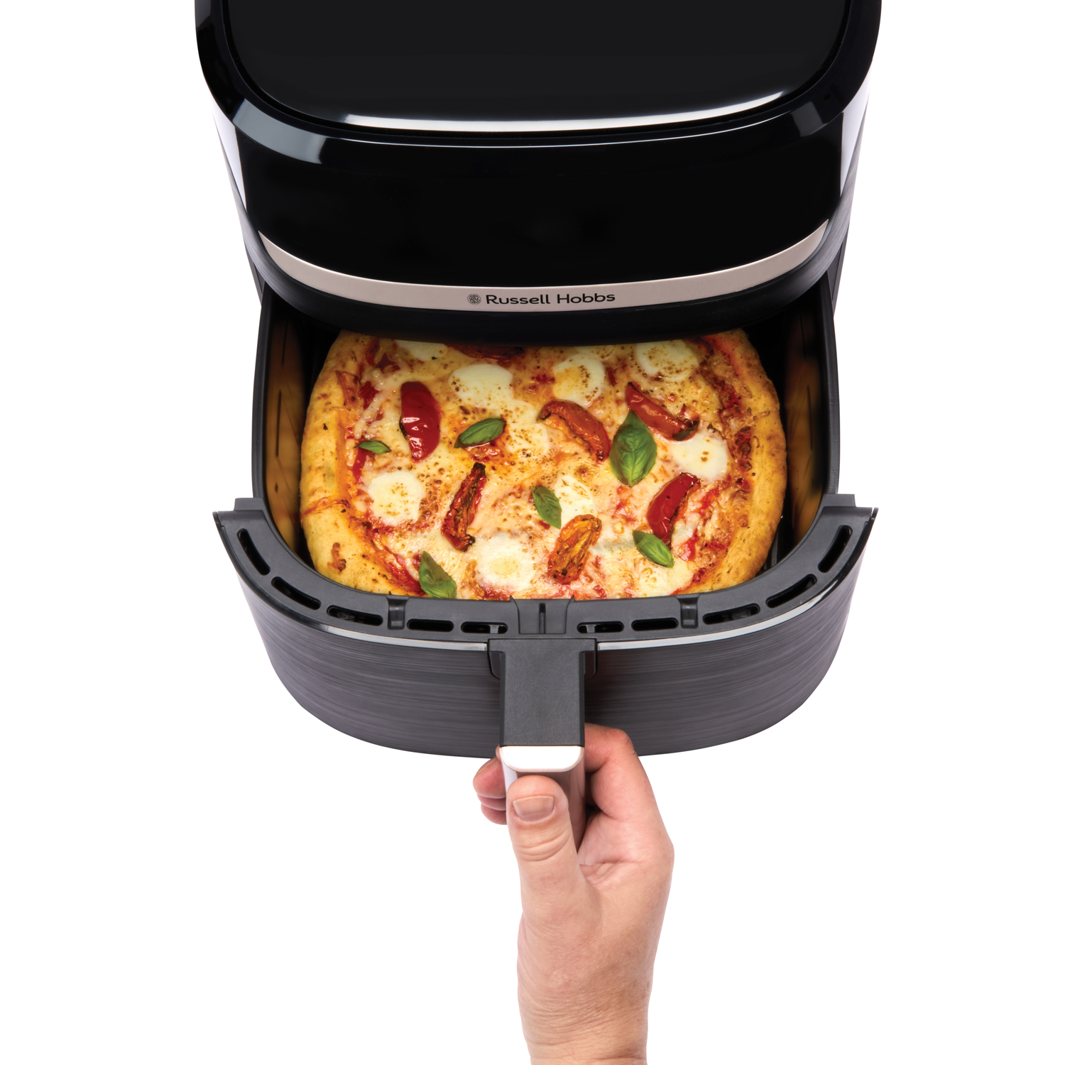 Een airfryer met een pizza erin. Een hand trekt de bak met de pizza eruit.