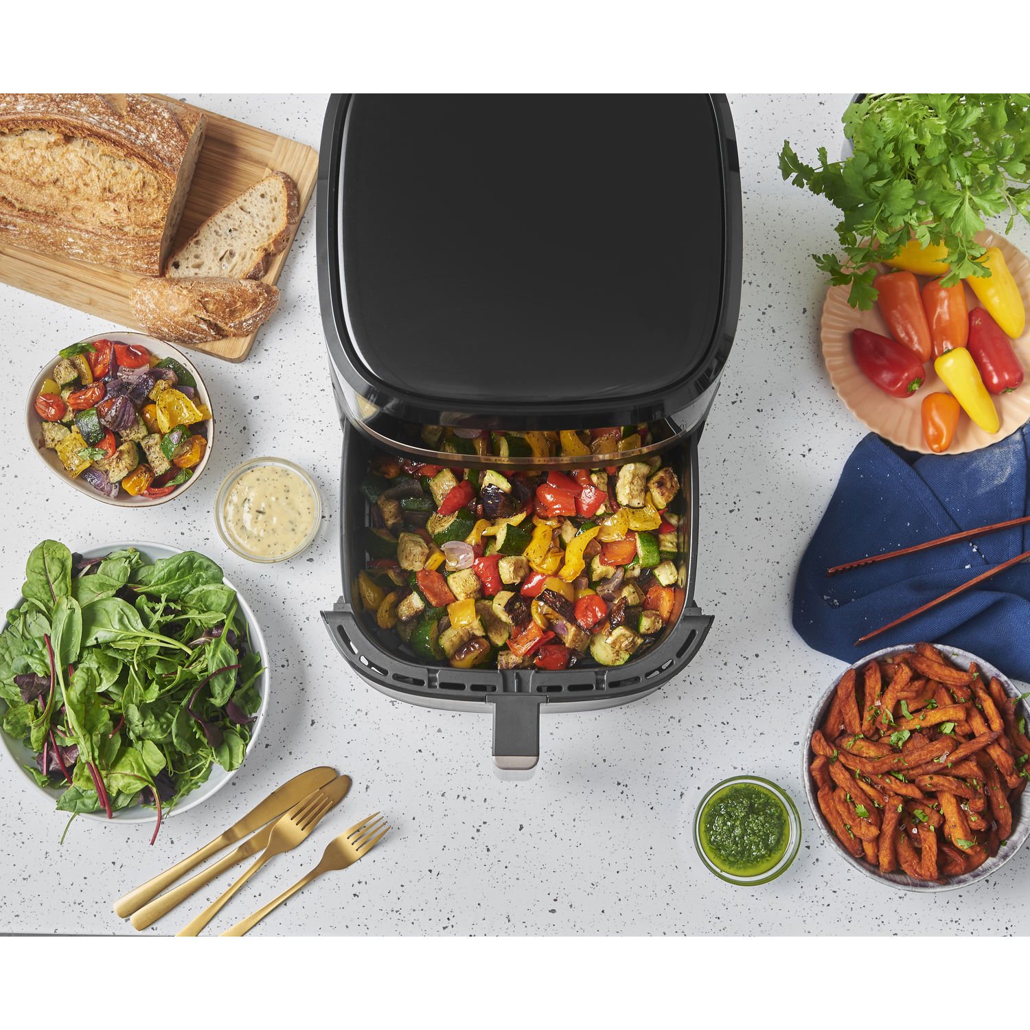 Airfryer met geroosterde groenten en bijgerechten.