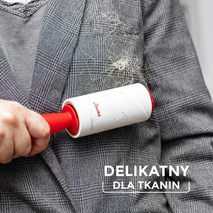 Osoba używa wałka do usuwania kłaczków na szarej kurtce w kratę.