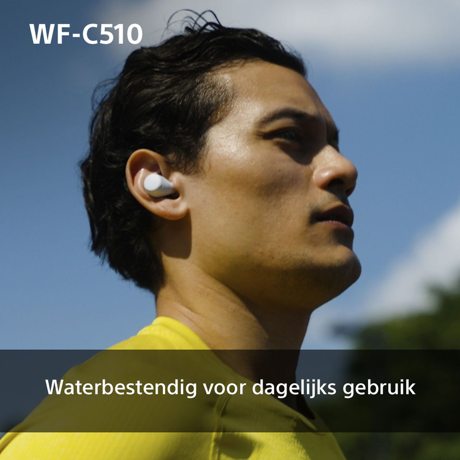 Man with earbuds. White earbud in ear. Text: Water resistant for daily use. Blue sky in the background.