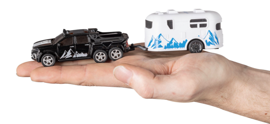 Ein schwarzer LKW zieht einen weißen Wohnwagen, der in einer Hand gehalten wird.