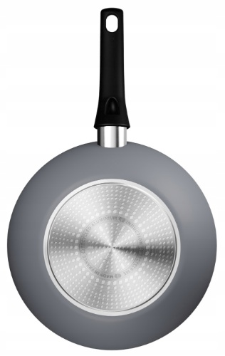 Szara patelnia z czarnym uchwytem, widok od dołu, na białej powierzchni.