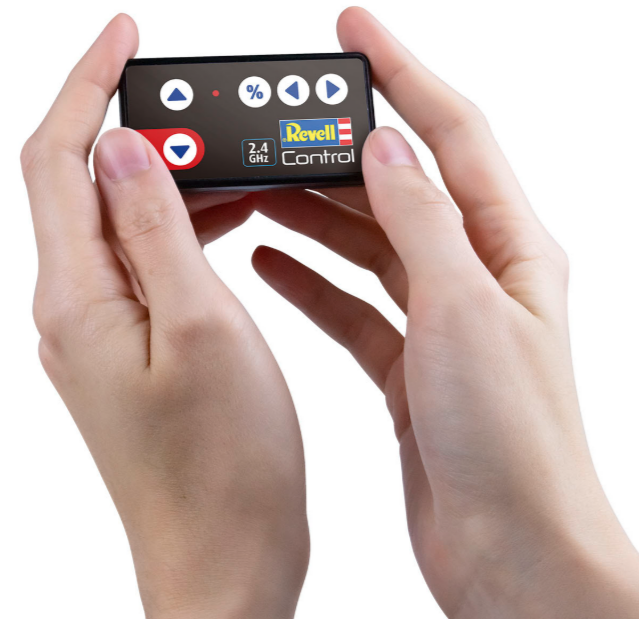 Hände halten ein schwarzes und rotes Revell Control Gerät. Es hat Knöpfe und ein Logo.