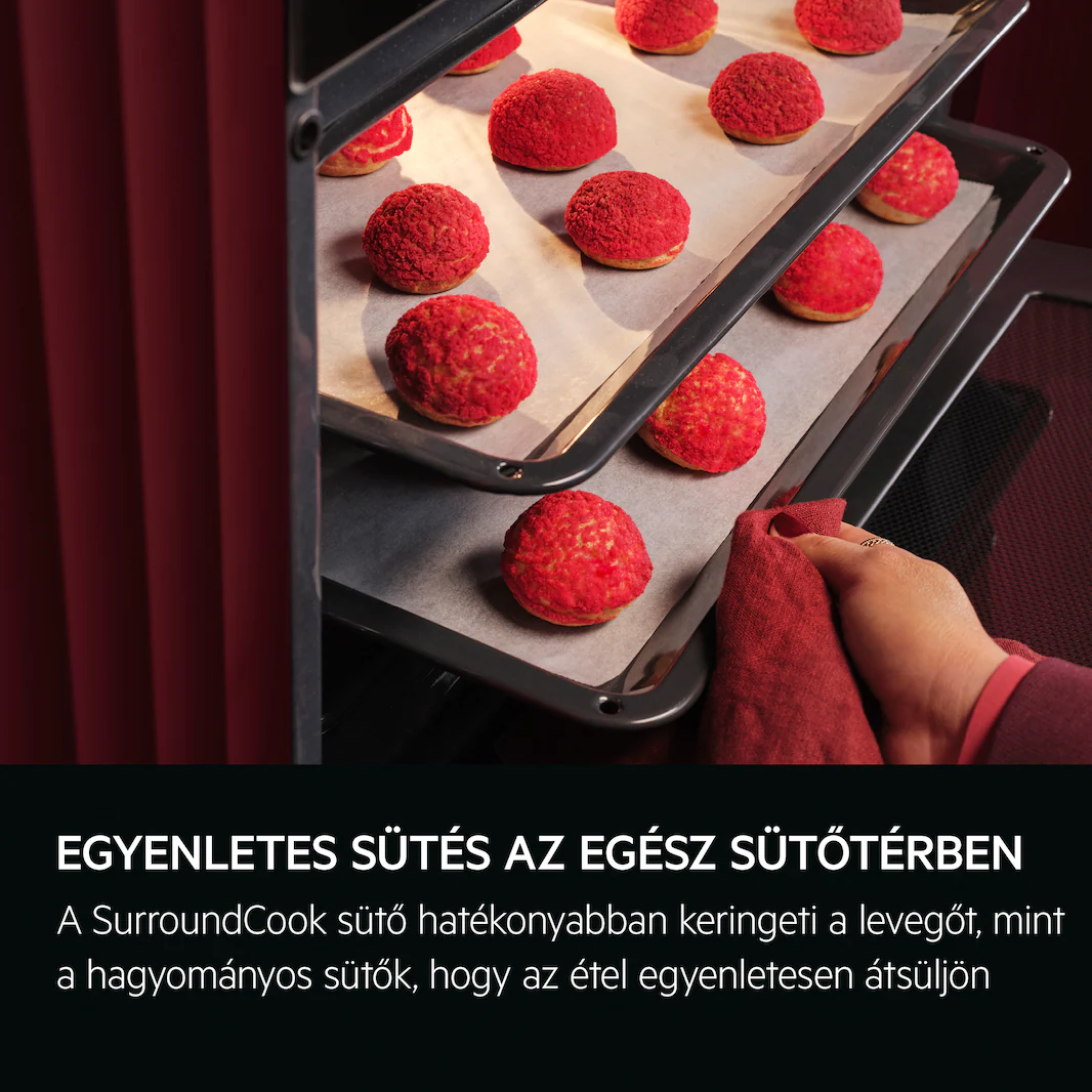 Egy vörös sütő közelképe, benne tepsik piros süteményekkel sülnek.