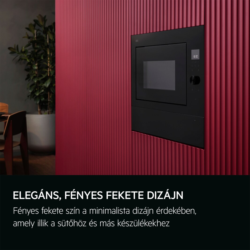 Egy fekete mikrohullámú sütő közelképe egy piros bordázott falba építve.