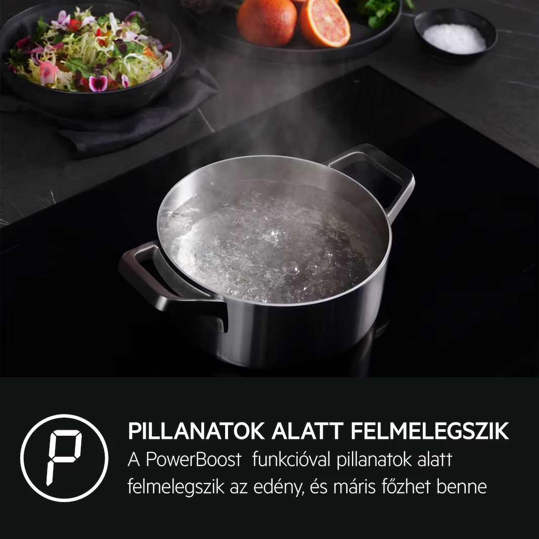 Főzőedény fekete tűzhelyen forrásban lévő vízzel. Étel és gyümölcs a háttérben.