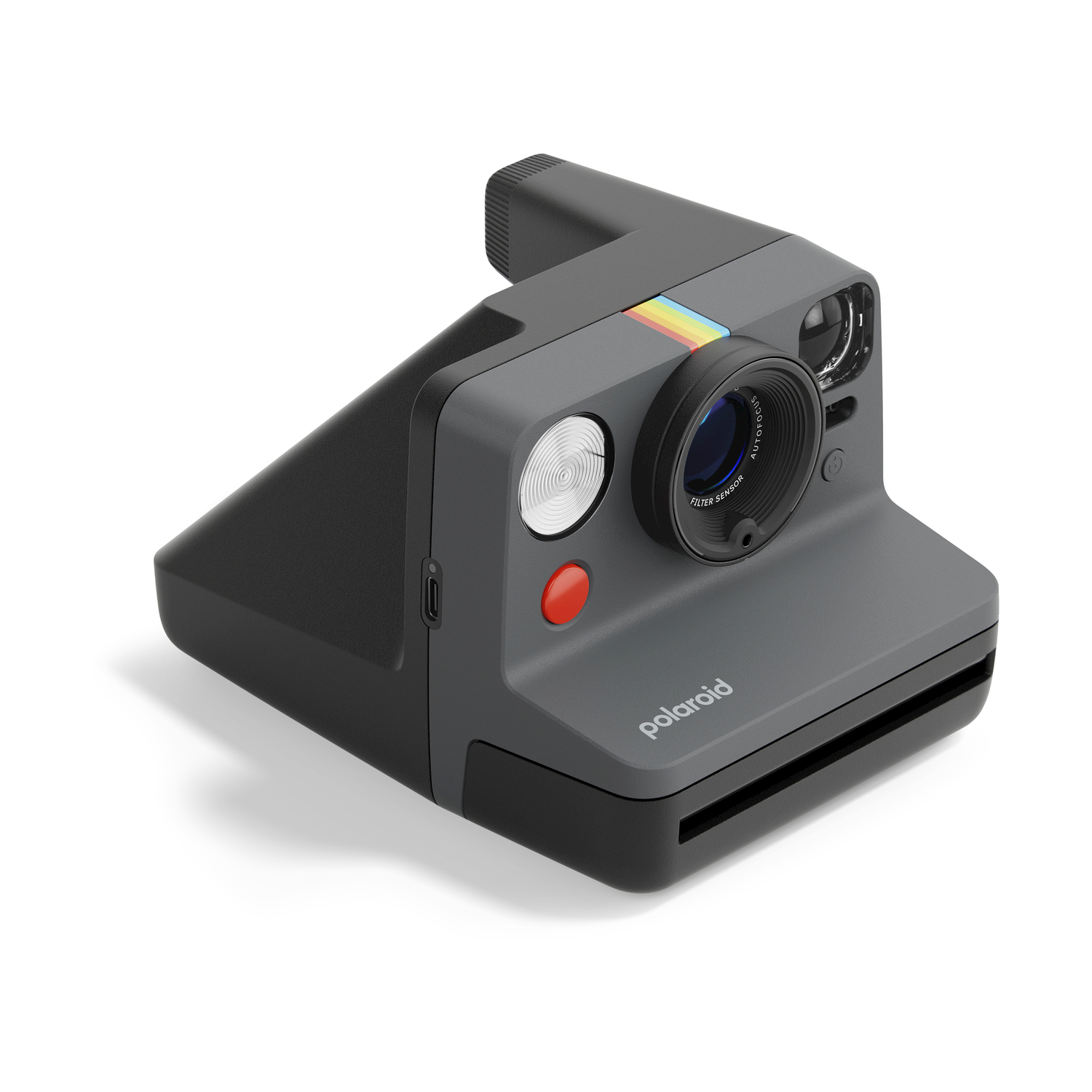 Fotocamera Polaroid grigia su bianco. Bottone rosso e striscia arcobaleno visibili.