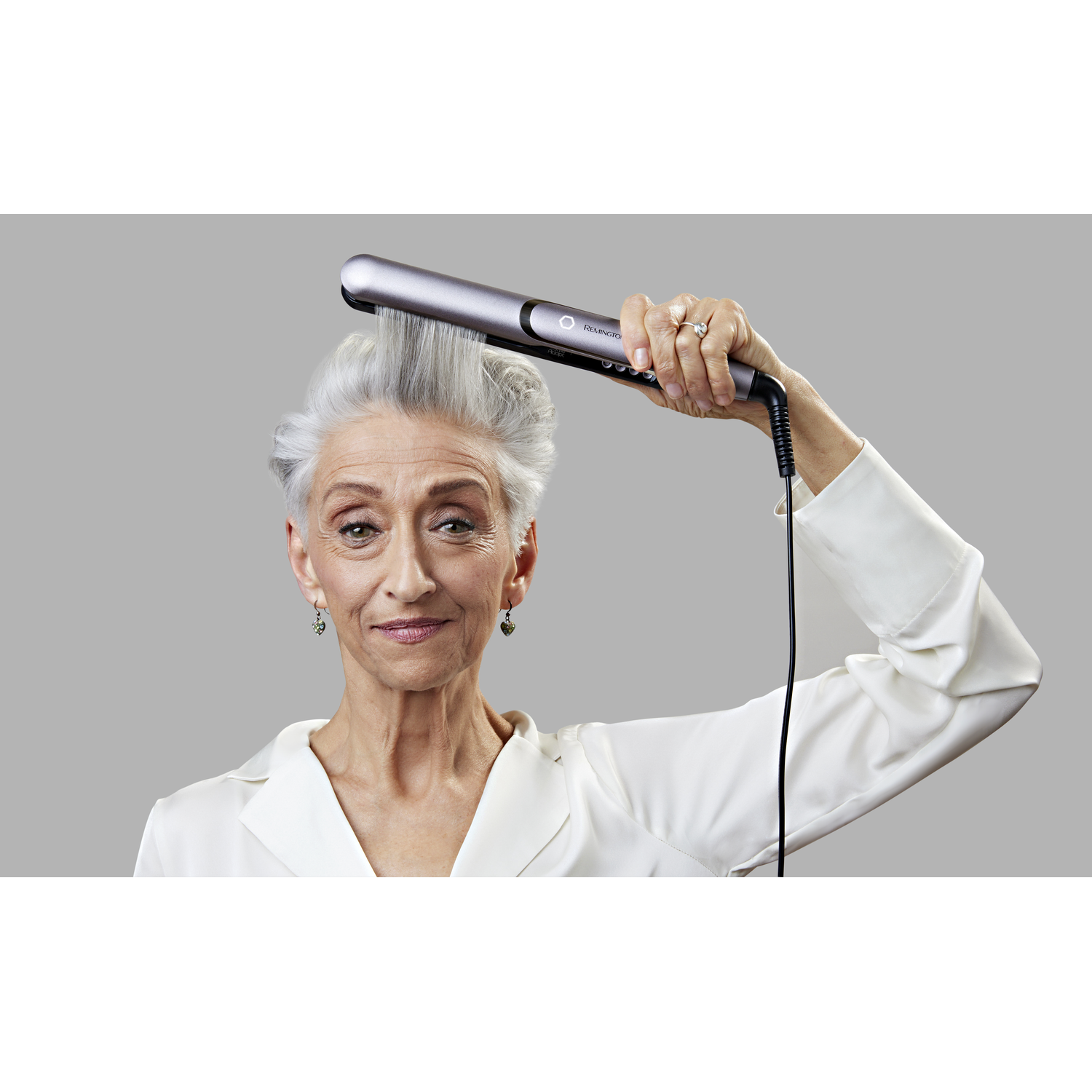 A hand holding a black and silver nose hair trimmer.