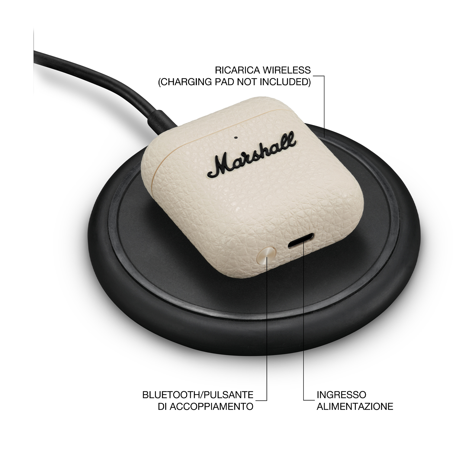 Custodia per auricolari Marshall color crema su un pad di ricarica wireless nero.
