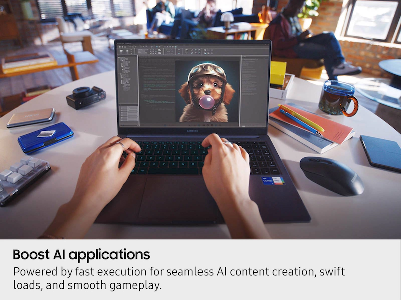 Személy kezei egy Samsung laptopon gépelnek, a képernyőn egy kutyás művészettel.