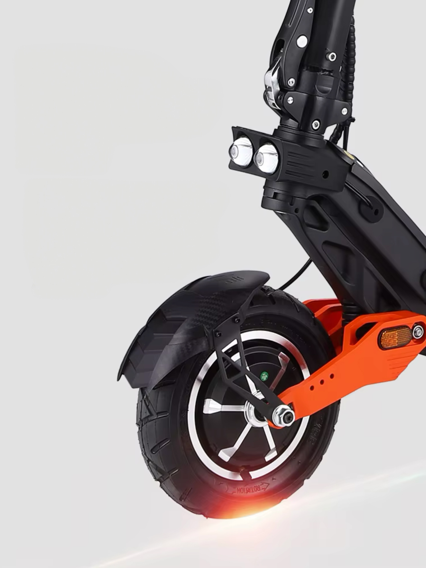 Elektrikli bir scooter'ın ön tekerleğinin yakın çekimi. Lastik siyahtır ve çatal turuncu ve siyahtır.