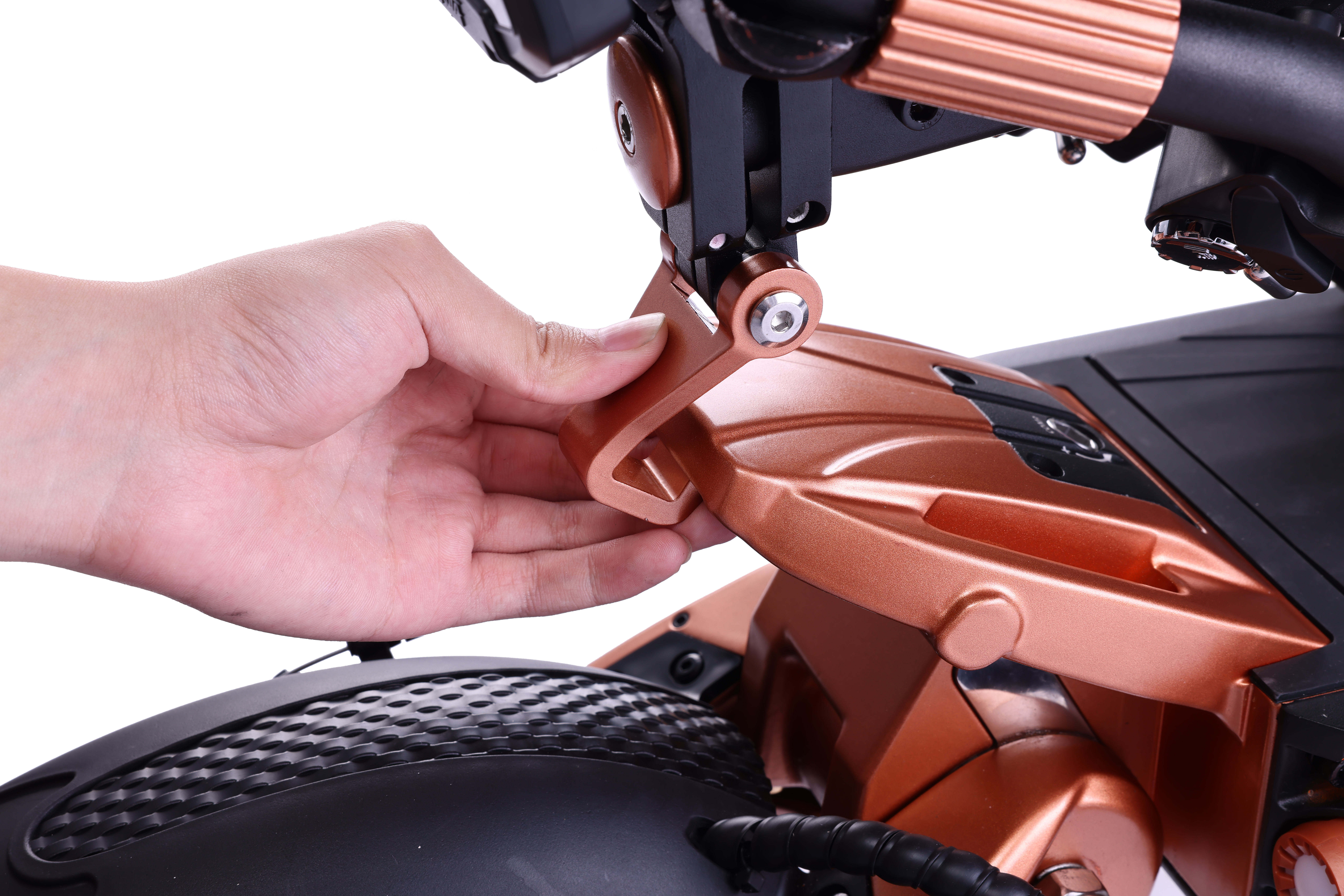 Bir el, bir scooter'ın bakır renkli bir parçasını ayarlıyor. Siyah ve bakır bileşenler beyaz bir arka plan üzerinde görülebilir.