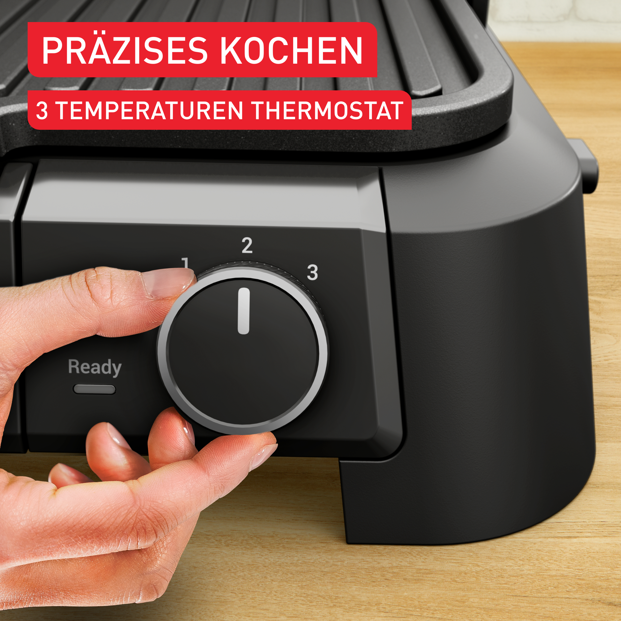 Eine Hand dreht einen Regler an einem schwarzen Grill. Text: 'PRÄZISES KOCHEN'.