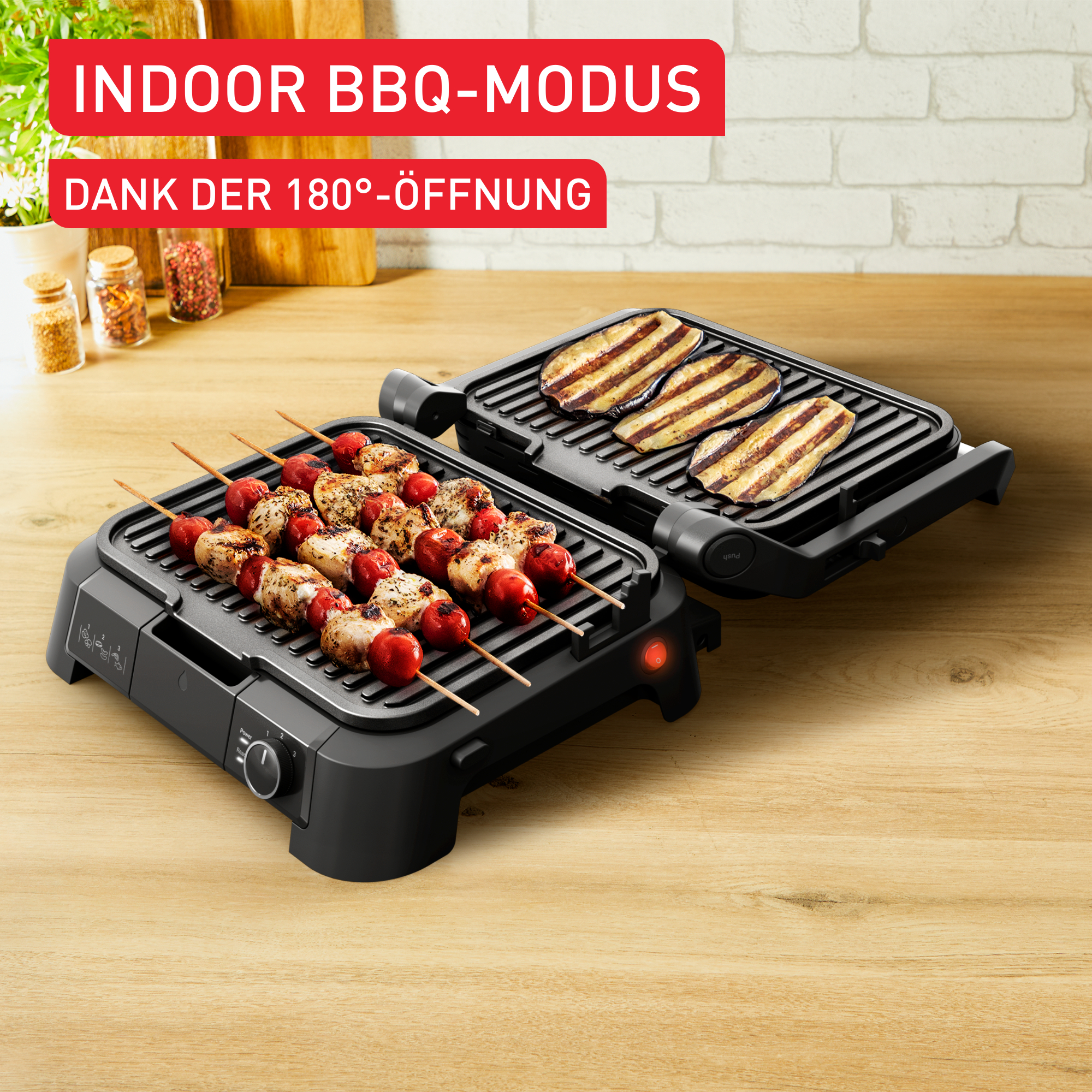 Ein Indoor-BBQ-Grill mit Spießen und gegrilltem Gemüse darauf, auf einem Holztisch.
