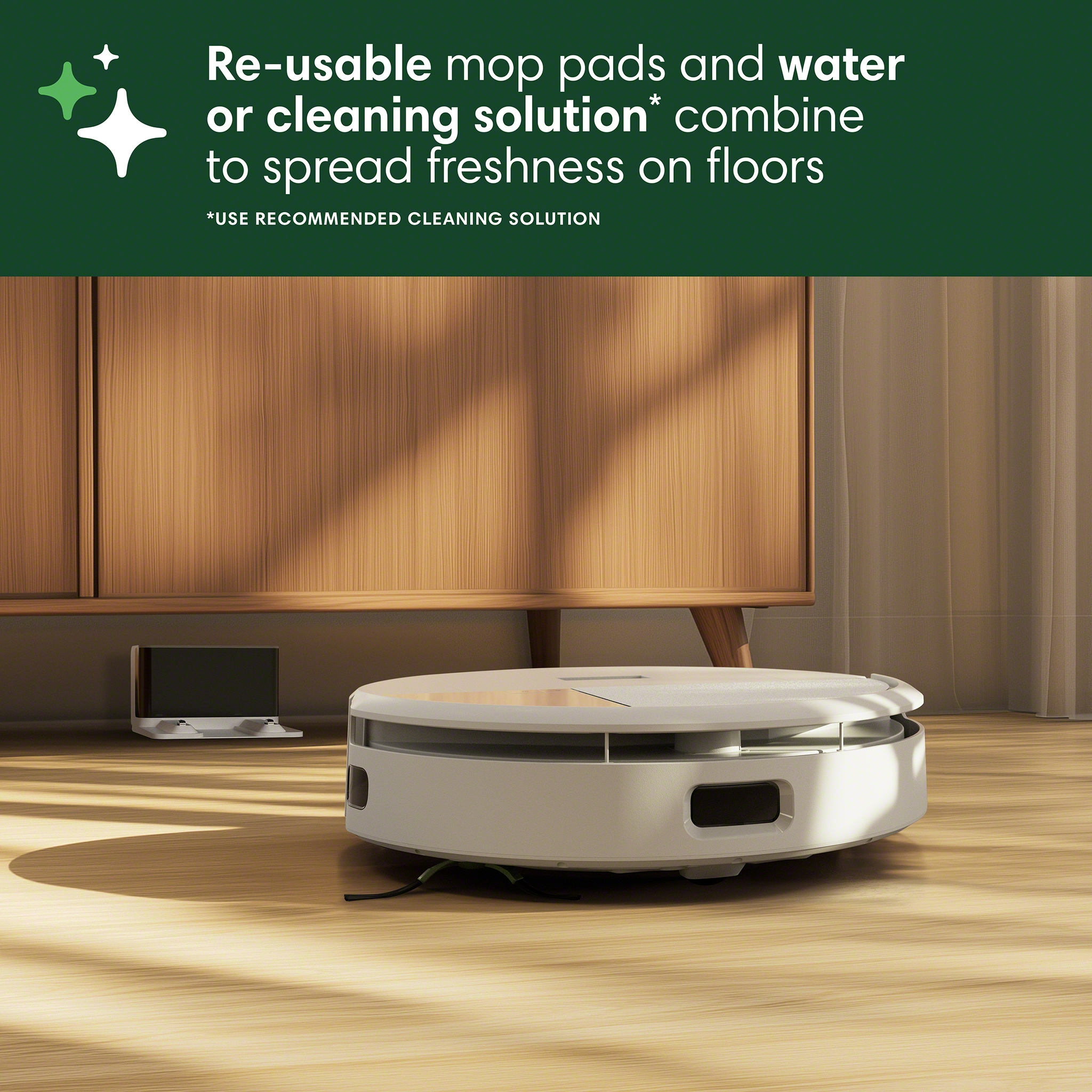 Un aspirateur robot sur un sol en bois près d'un meuble.