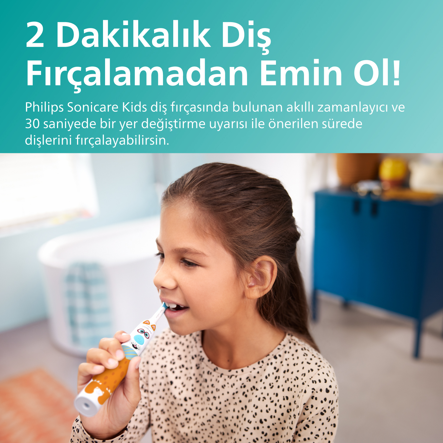 Kız, elektrikli diş fırçası ile dişlerini fırçalıyor. Beyaz banyo, mavi dolap.