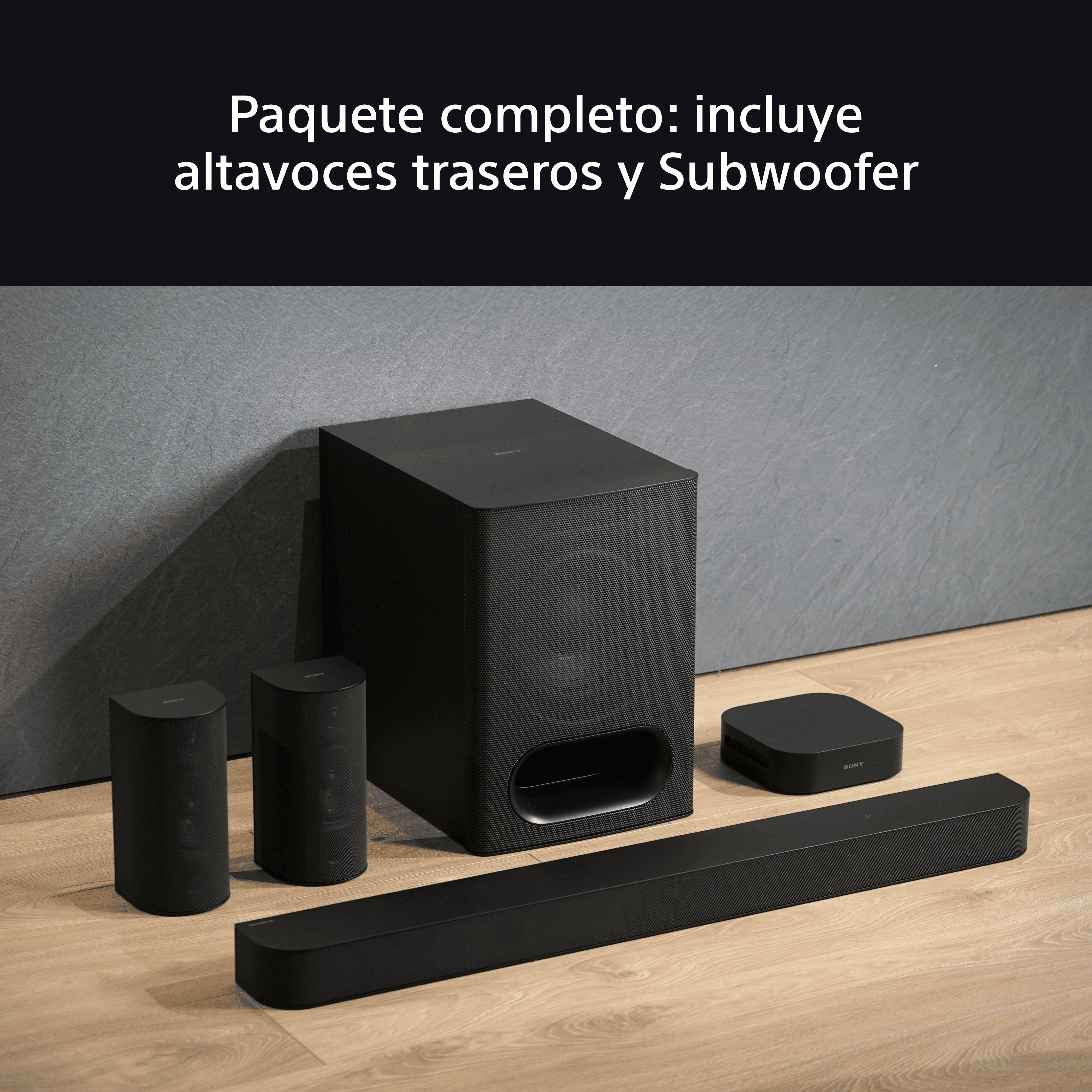 Sistema de cine en casa negro con altavoces y subwoofer en un suelo de madera.