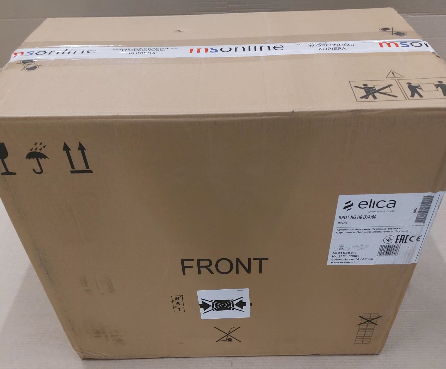 Brązowe kartonowe pudełko z etykietami, strzałkami i tekstem: 'FRONT'.