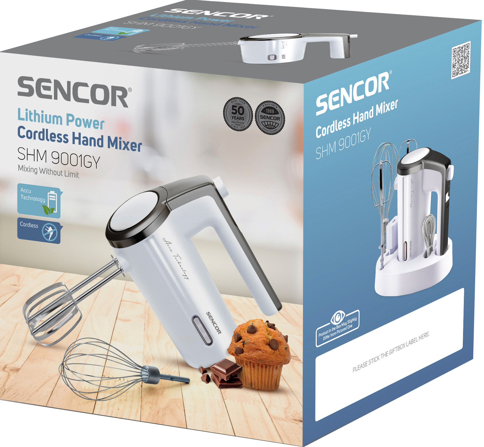Kézi mixer dobozzal, süteménnyel és csokoládéval. A mixer fehér és szürke.